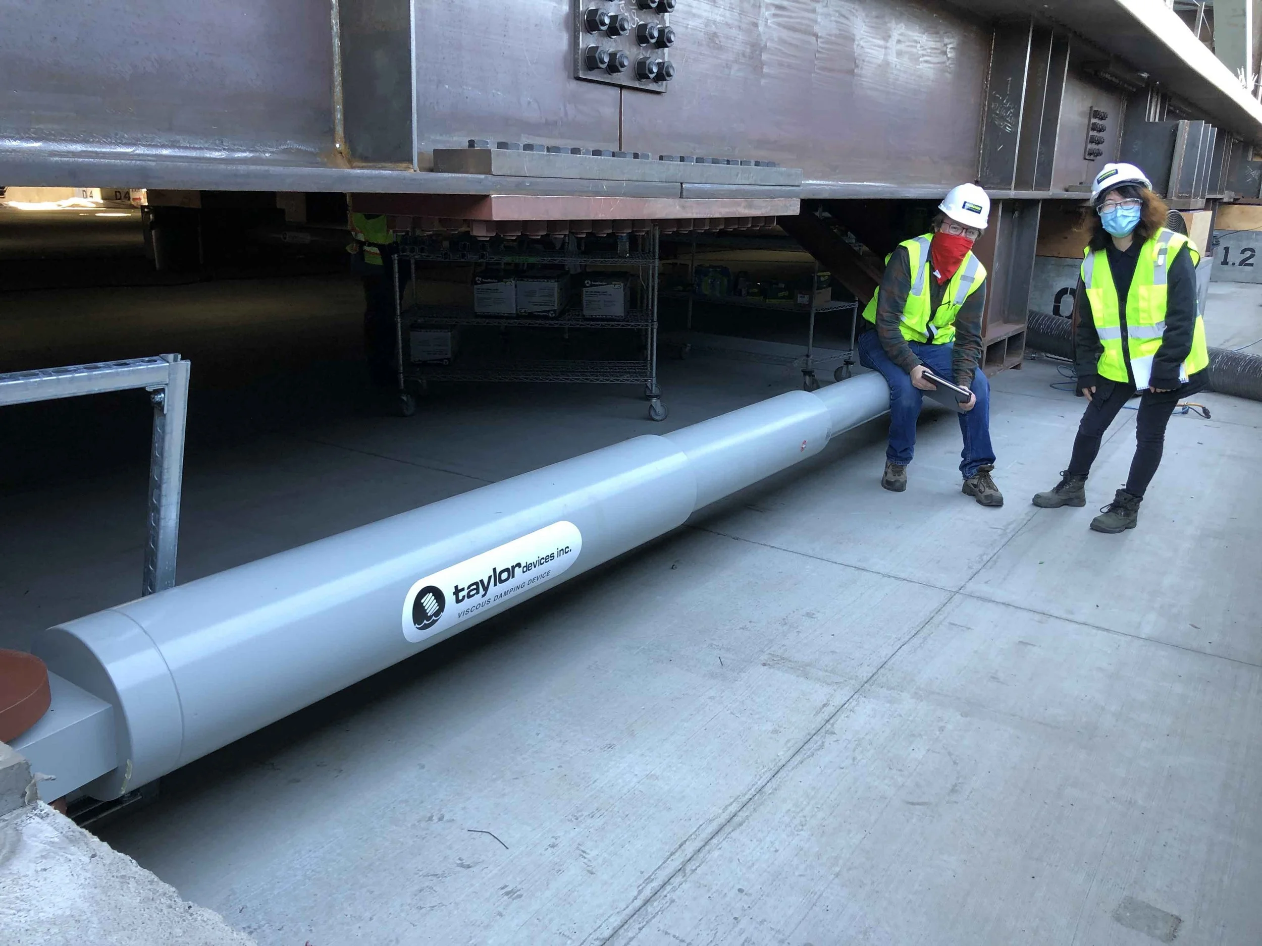 Onsite inspection view of the PARADIGM Structural Engineers NTT SV1 data center featuring engineers alongside a large Taylor Devices seismic damper system.
