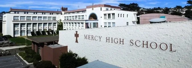 PARADIGM Structural Engineers Mercy High School campus exterior view showing the prominent white walled entrance sign and school buildings.