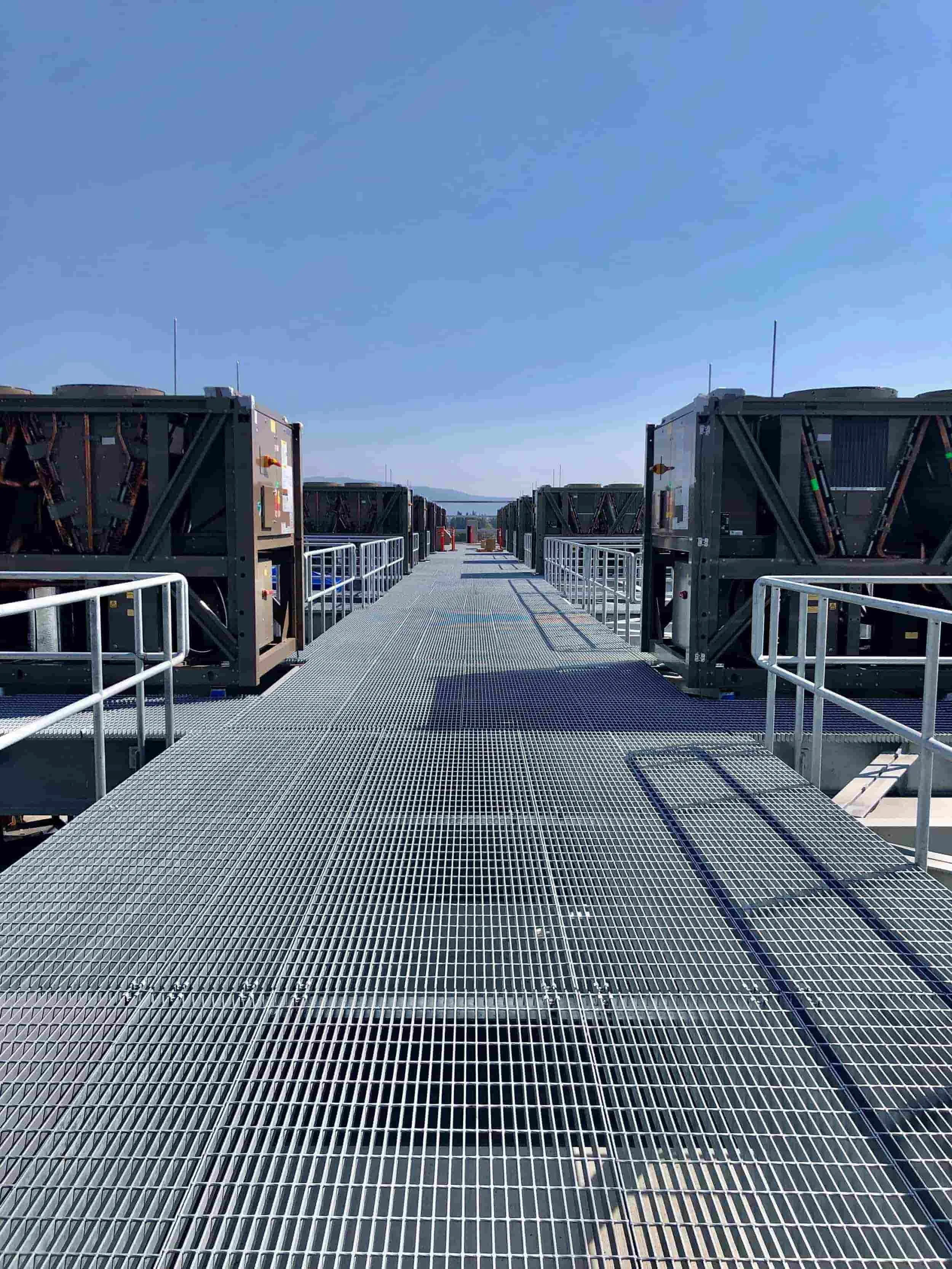 Rooftop view of the PARADIGM Structural Engineers NTT SV1 data center featuring industrial HVAC equipment and metal grating walkways with safety railings.