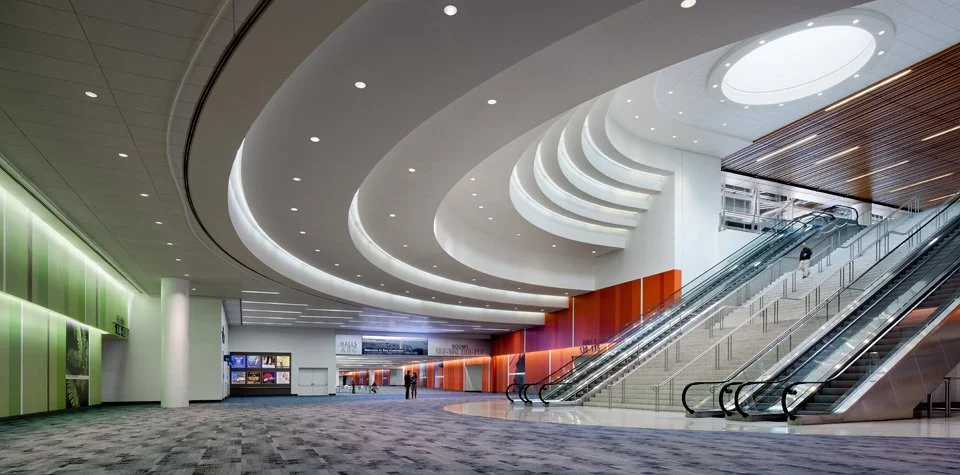 Interior view of the Moscone Center North Lobby in San Francisco featuring curved layered ceilings, escalators, and structural engineering by PARADIGM.