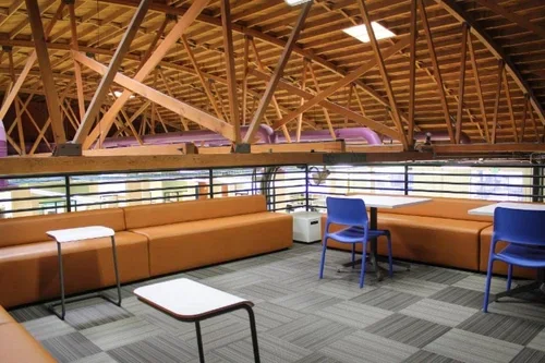 Interior view of Ascend Clinical featuring modern seating areas under exposed timber roof trusses, showcasing structural engineering.