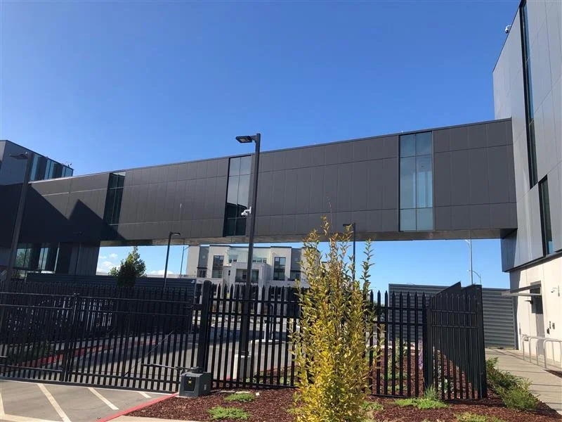 Exterior view of the PARADIGM Structural Engineers Equinix SV11 data center facility featuring an elevated skybridge connecting buildings and security fencing.
