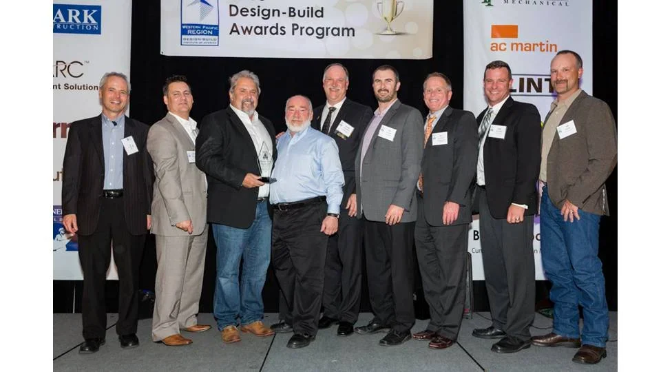 PARADIGM Structural Engineers team members and project partners accepting an award on stage at the Design-Build Awards Program.