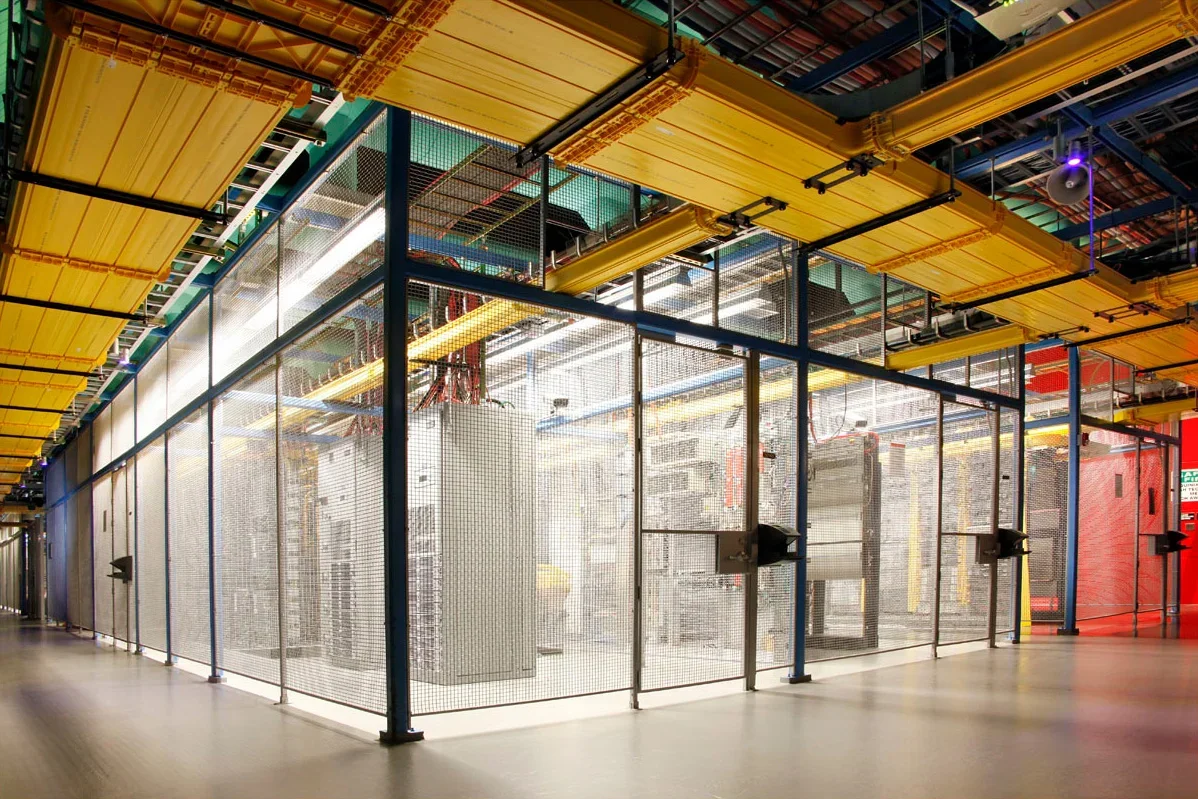 Interior view of the Equinix SV5 data center server room, showcasing secure caging, server racks, and overhead cable trays.