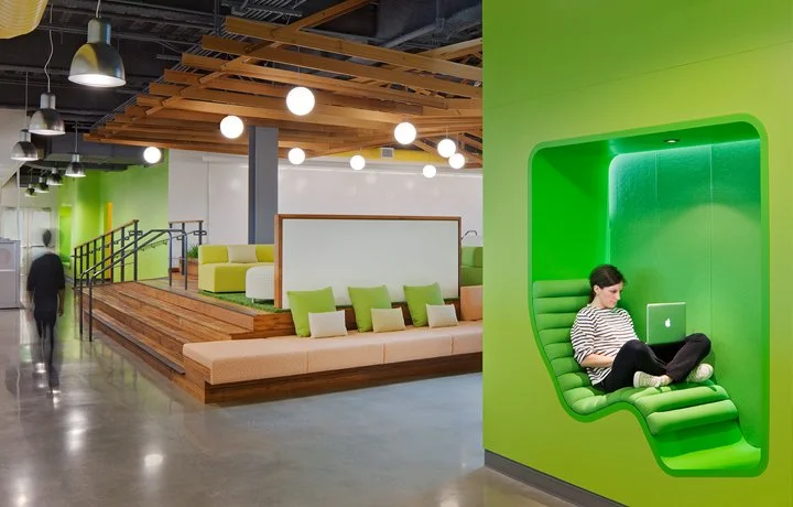 Side-by-side interior views designed for PARADIGM Structural Engineers featuring an open office breakout area with tiered wooden seating and a person working inside a recessed, bright green built-in wall nook.