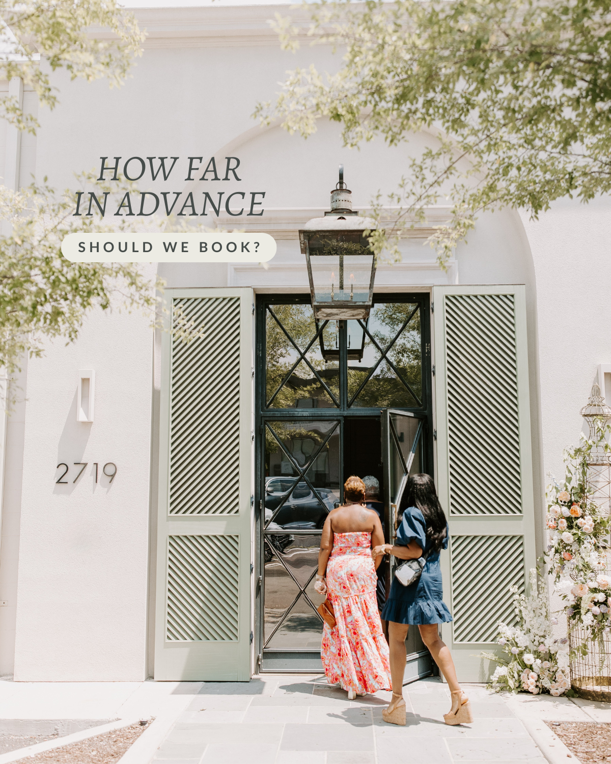 Two women walking into an elegant white building with large open doors, floral arrangements on the side, and a sign asking 'How far in advance should we book?'