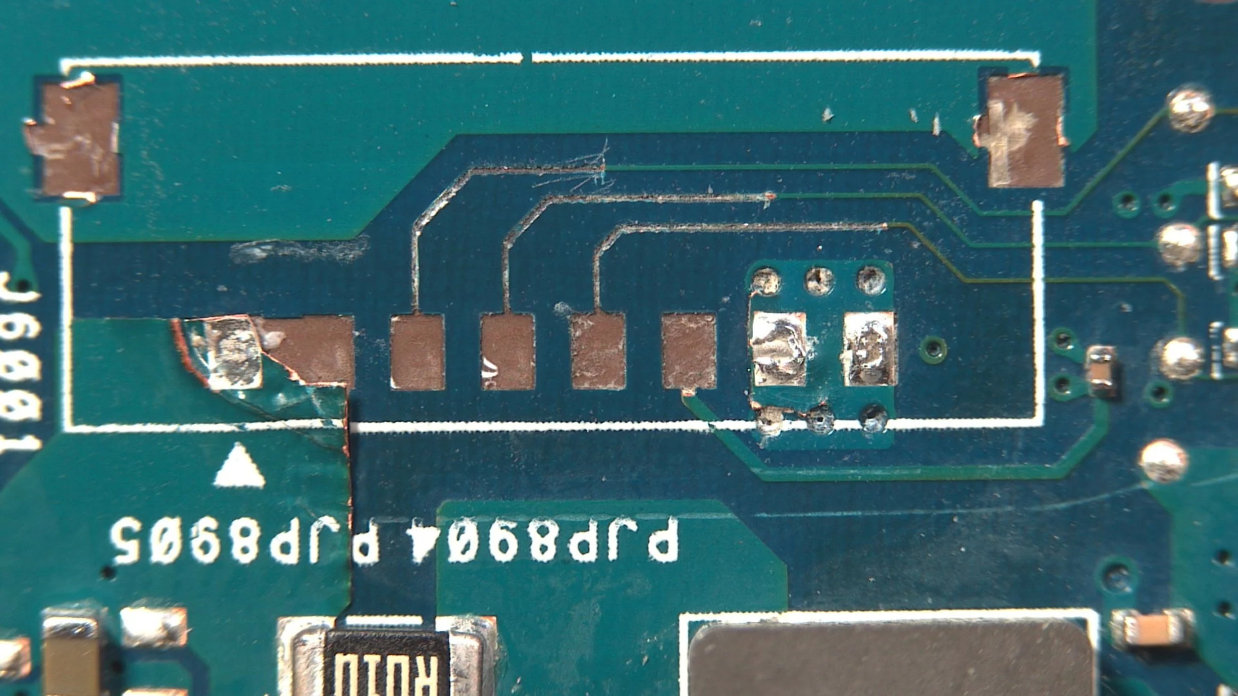 Ripped battery connector and torn solder pads on an Asus Vivobook S 16X laptop motherboard