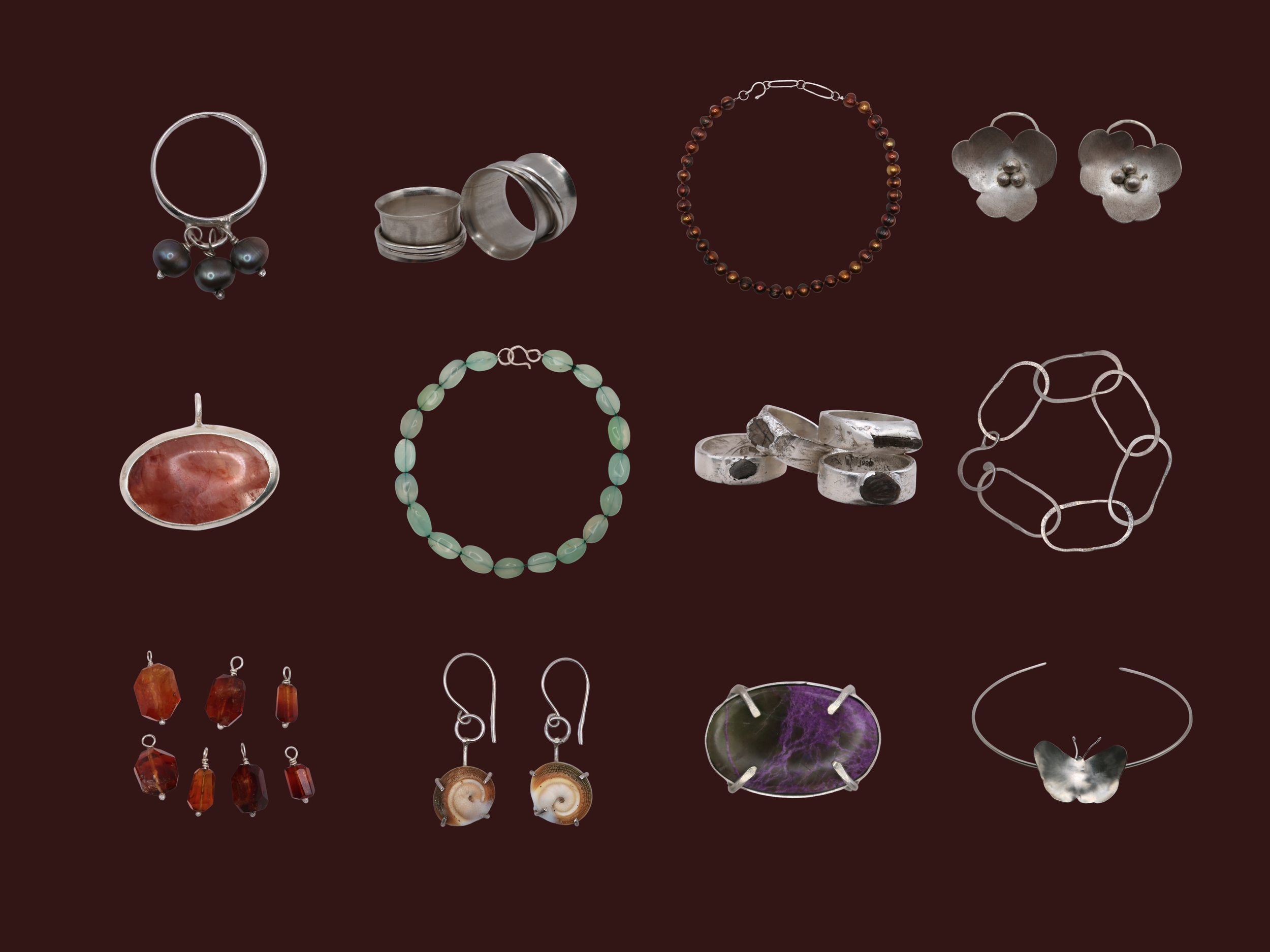 Assorted silver jewelry and gemstone earrings, necklaces, and rings displayed on a dark background.