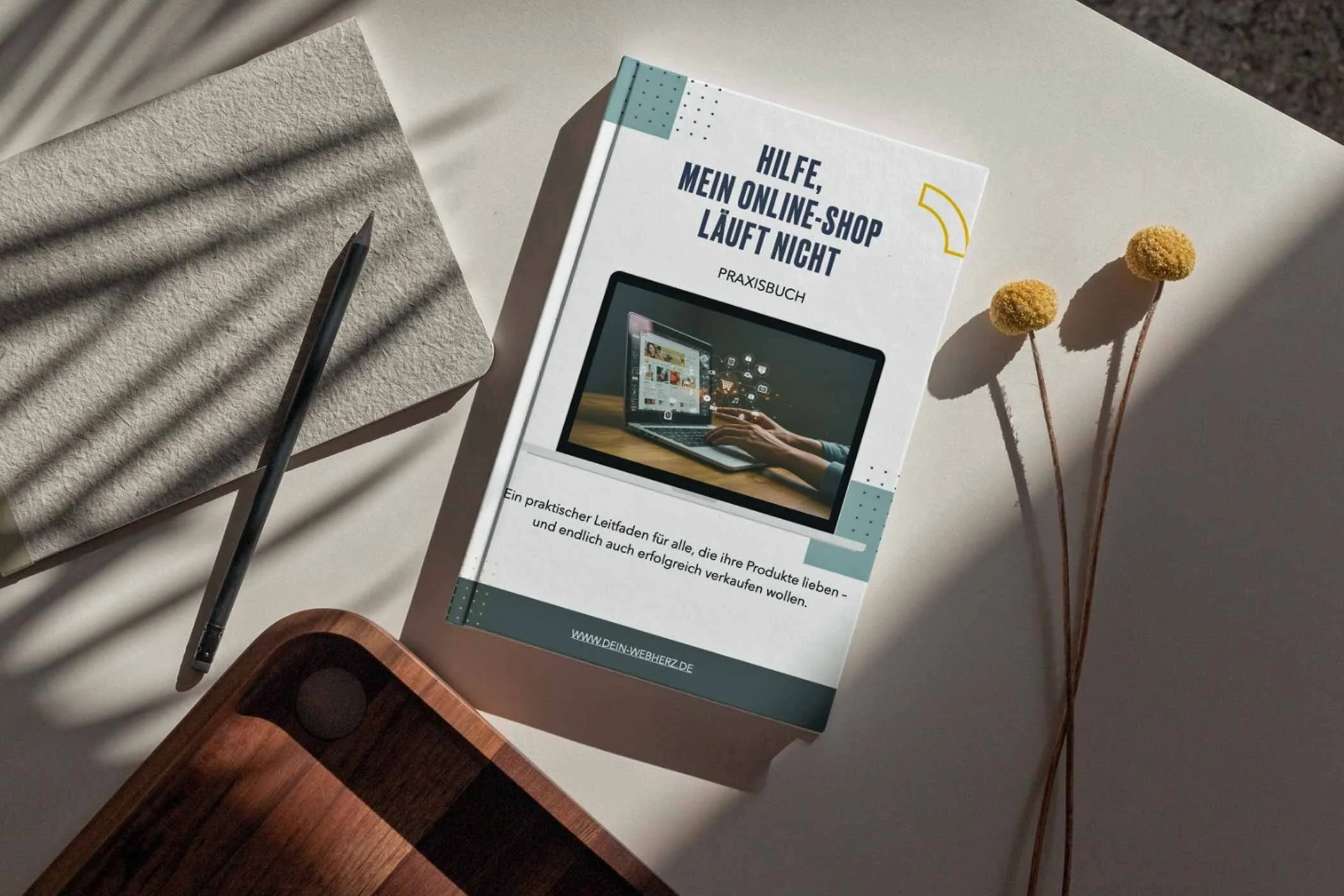 Das Ebook mit dem Titel Hilfe, mein Online-Shop läuft nicht, liegt auf einem Tisch.