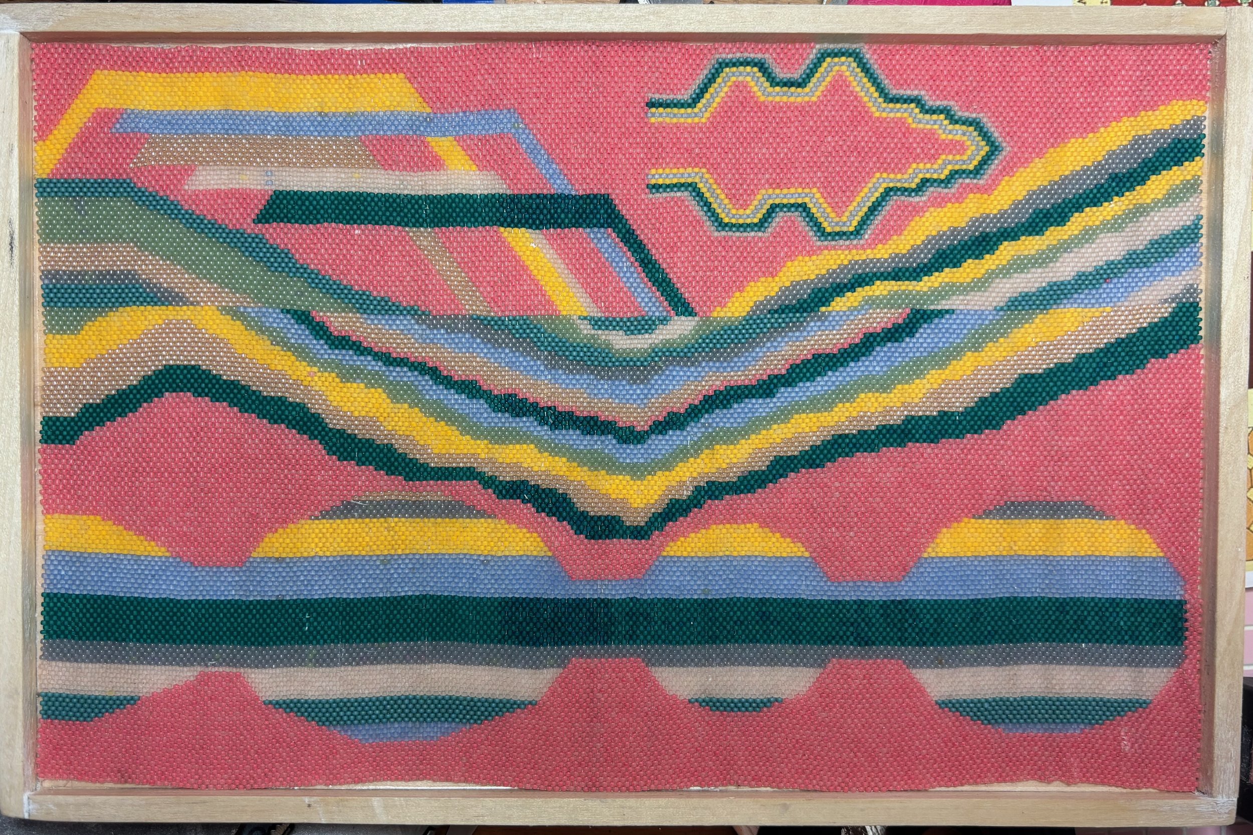 An abstract tapestry. The color is predominantly pink, with greens, blues, and yellows.