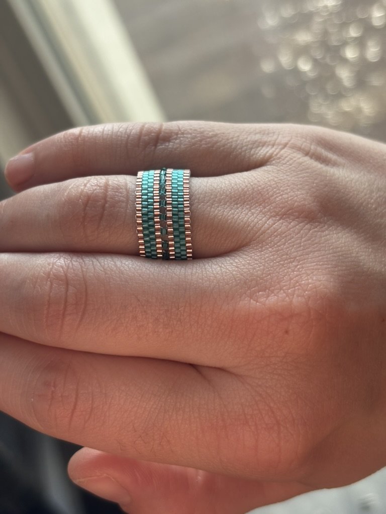 The Mirror Stacked Aqua Rose ring displayed on a hand