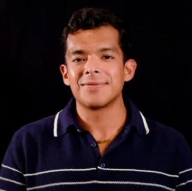 A young man with short curly hair, smiling, wearing a navy blue polo shirt with white stripes, against a black background.