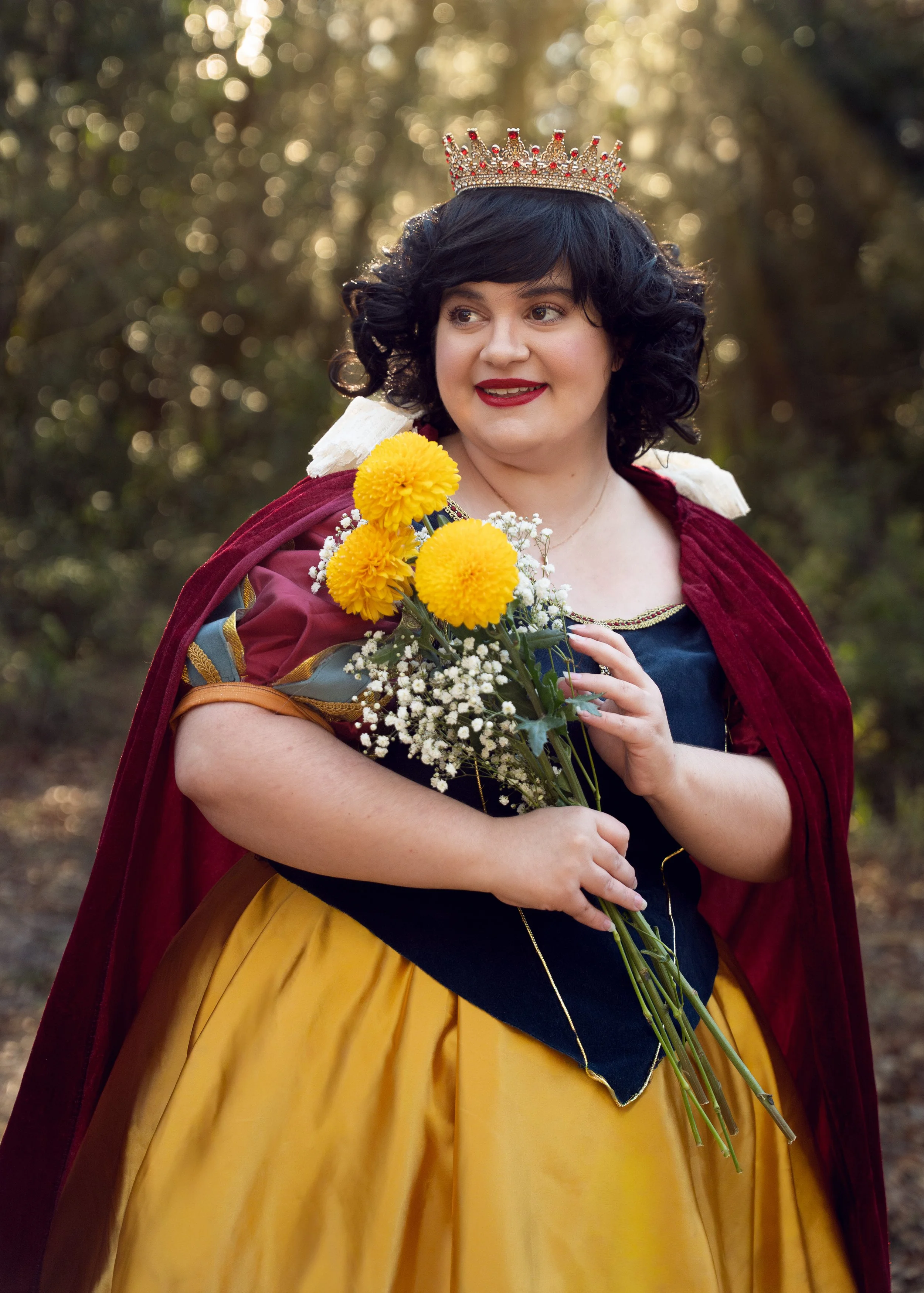 Image of woman dressed as Snow White, holding a bouquet of yellow and white flowers.