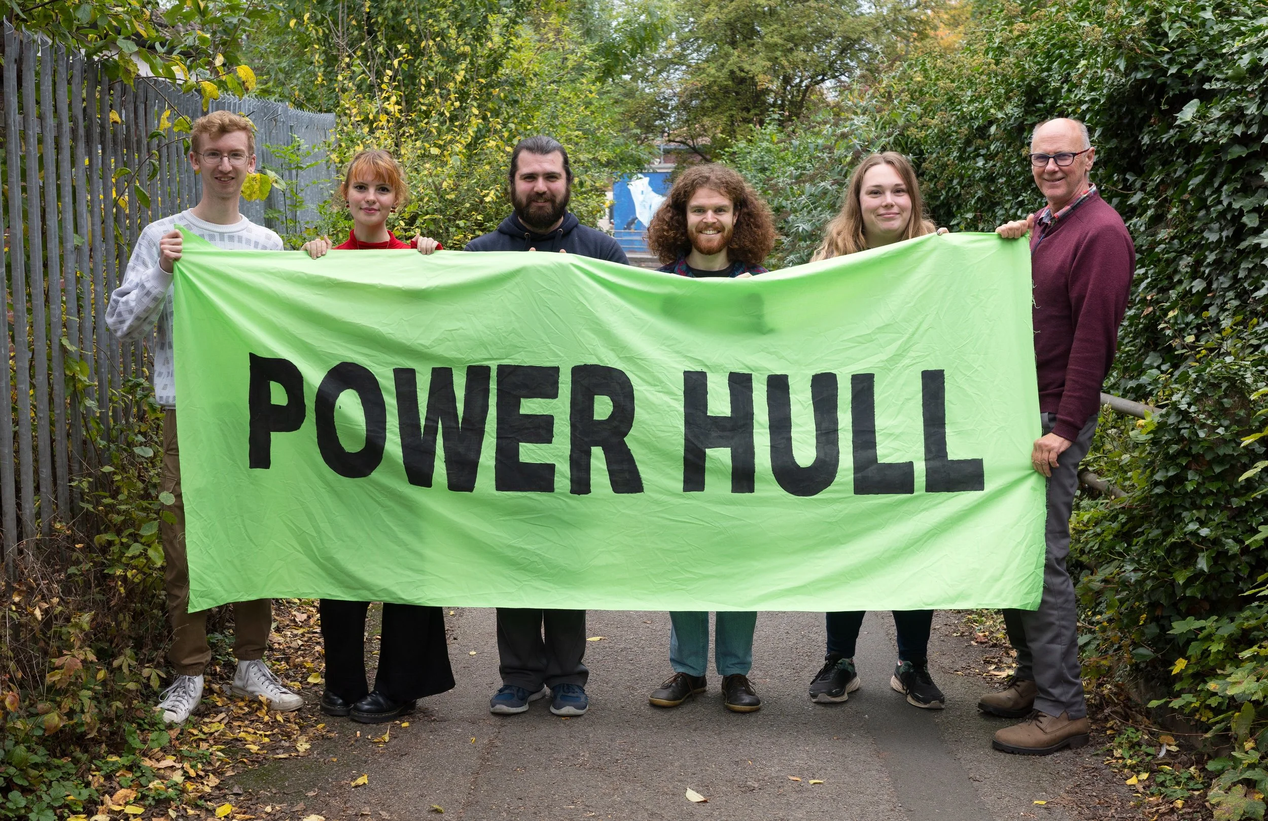 Picture of the Power Hull team: 6 people holding a green Power Hull banner.