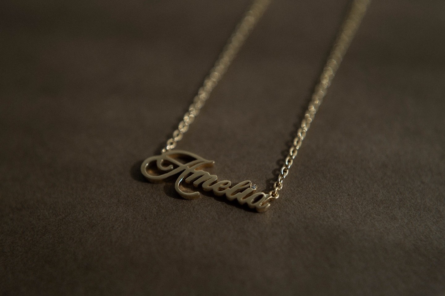 A name made luminous &mdash; a personal signature in solid 18k gold, kept close to the heart.