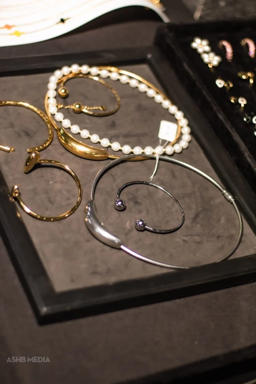 Jewelry set in a black display box, including pearl necklace, gold-colored earrings, and a silver bracelet and earrings.