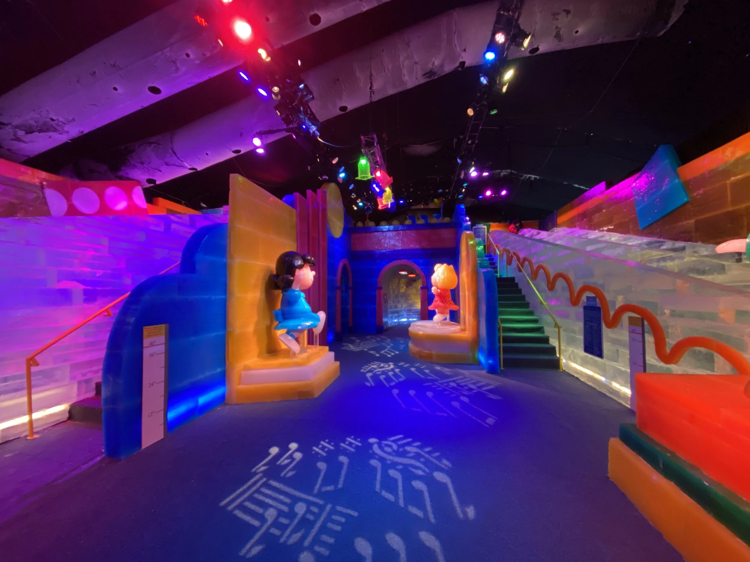 Colorful indoor playground with animated characters, bright lights, and vibrant decor, designed for children.