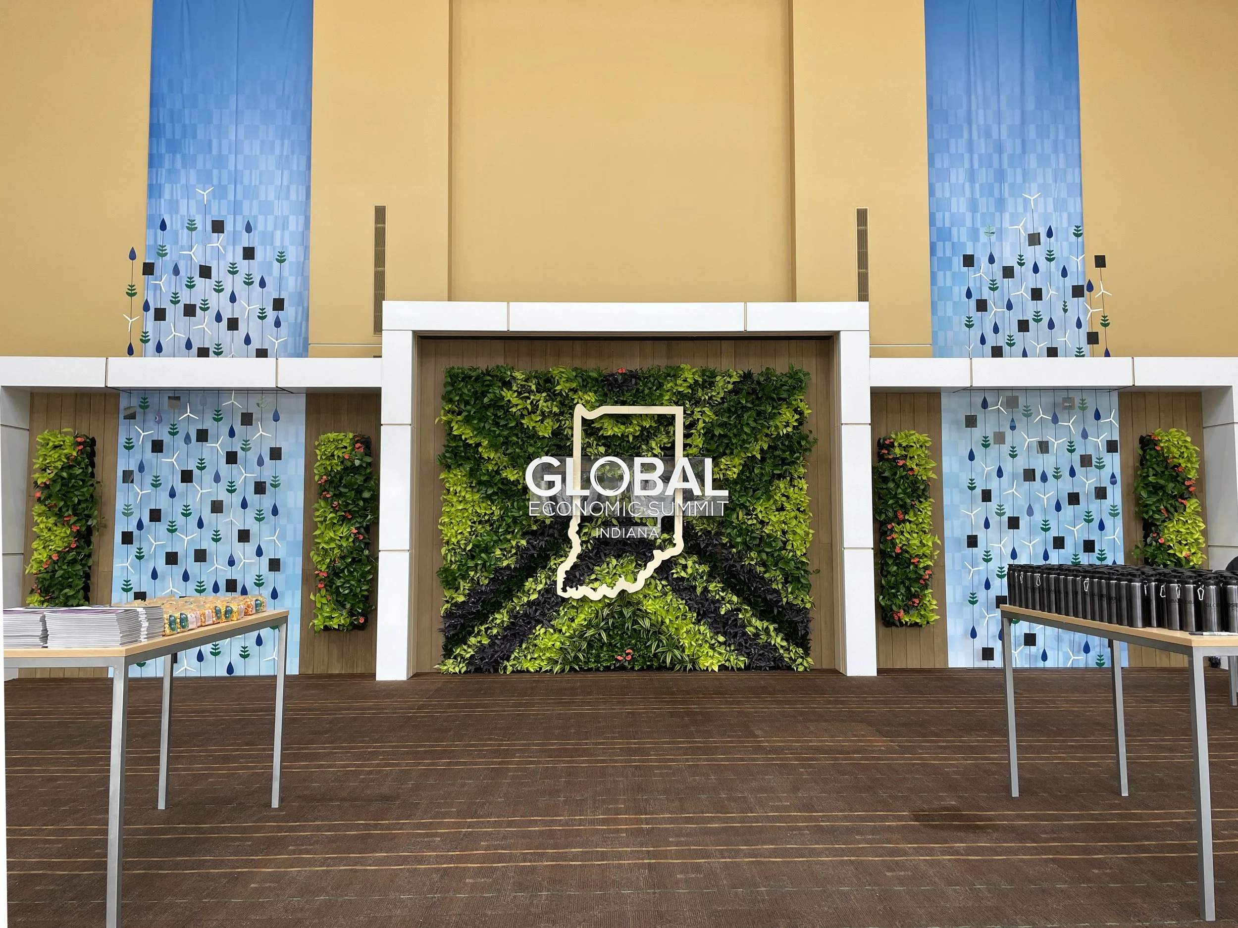 Registration area for the Global Economic Summit in Indiana featuring a green leafy background and a white outline of Indiana with the summit title.