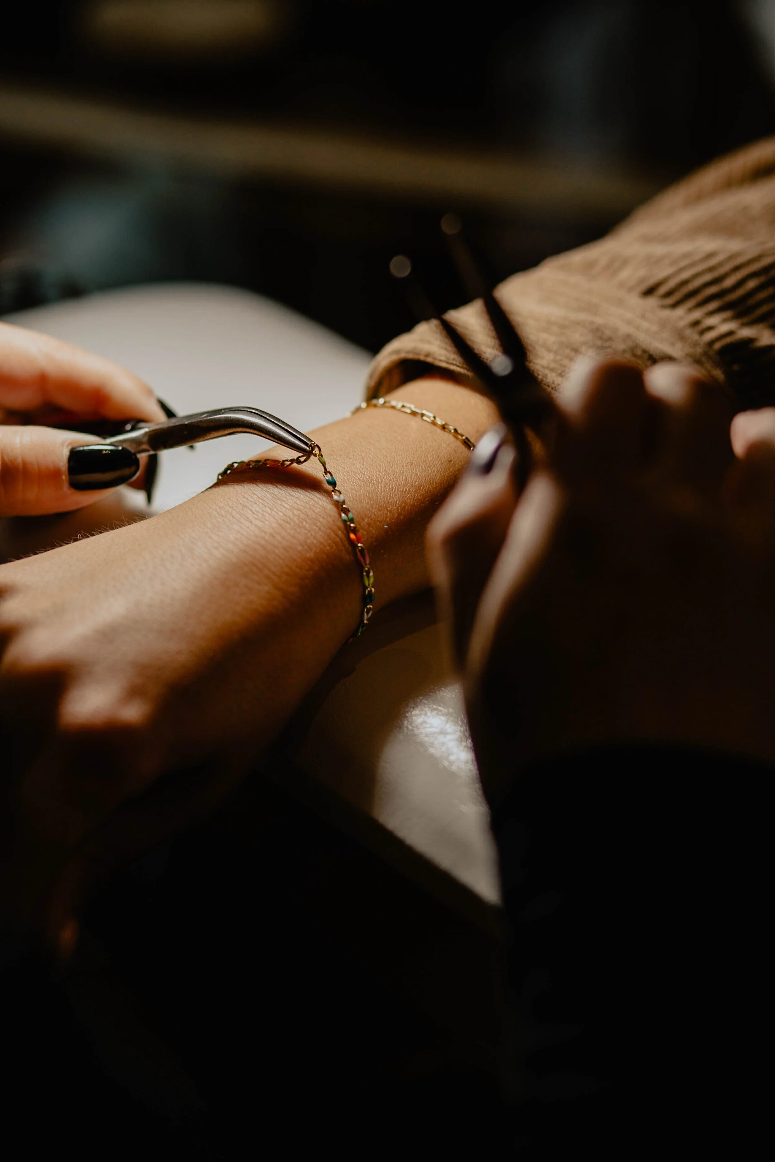 A person getting a bracelet on their wrist at a jewelry store or salon, with a jeweler or technician assisting. Seattle professional head shot photography