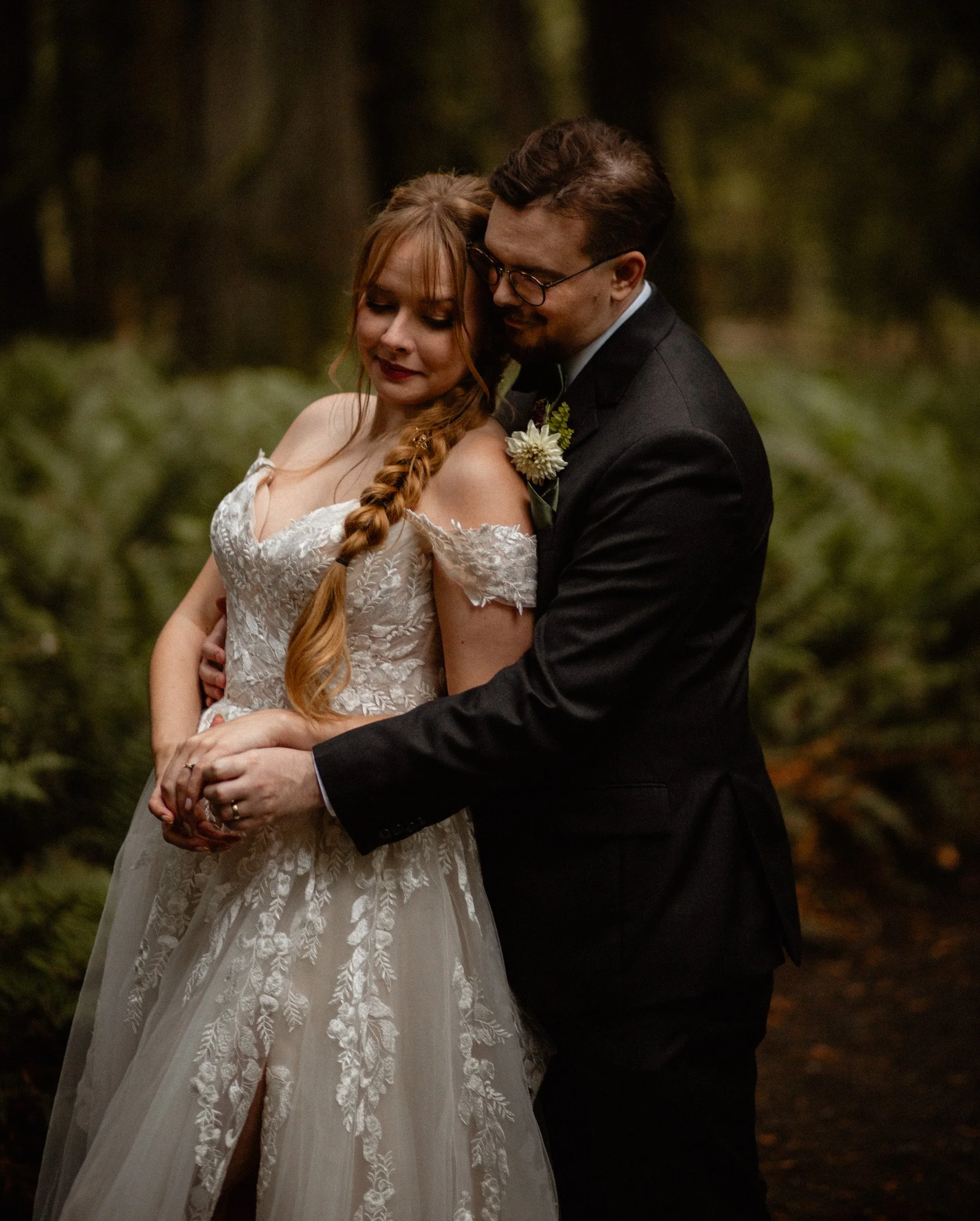 Bride and groom walking hand-in-hand through the forest during their Lake Crescent wedding at Lake Crescent Lodge.