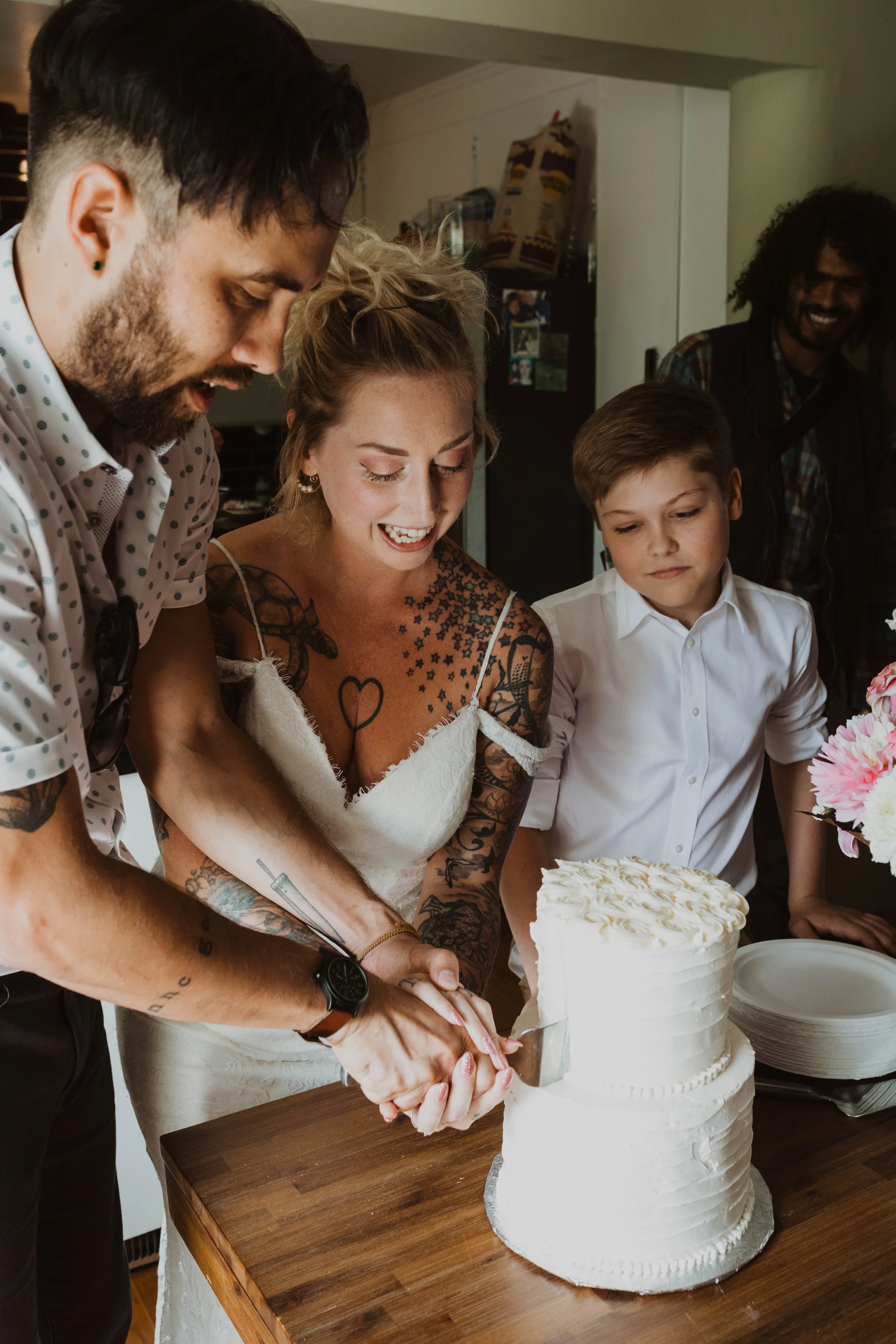 People cutting a wedding cake at a celebration. Seattle, WA wedding photography.