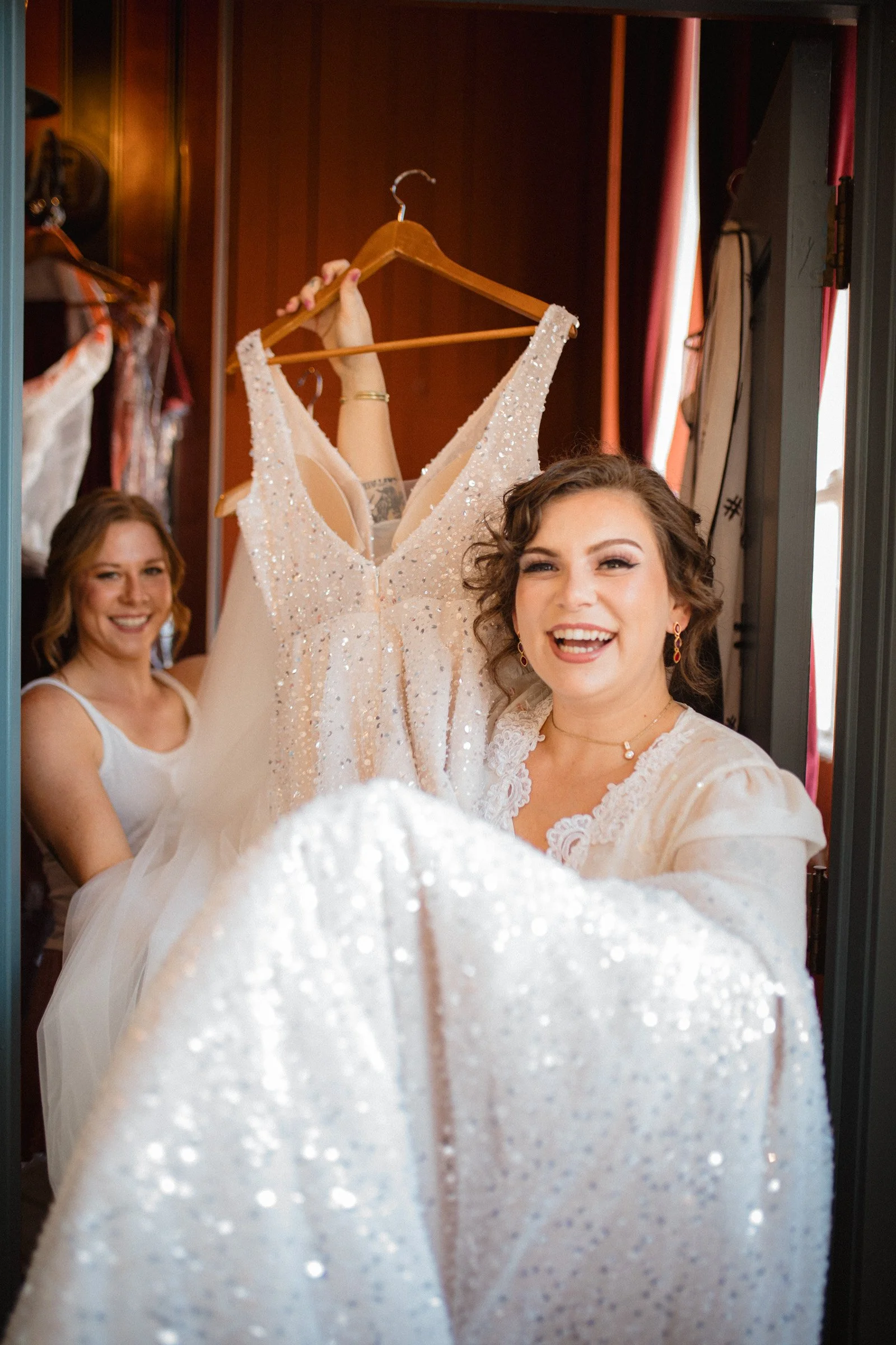 Bride carries here shimmering wedding dress moments before she dawns it in her bridal suite at The Ruins in Queen Anne, Seattle.