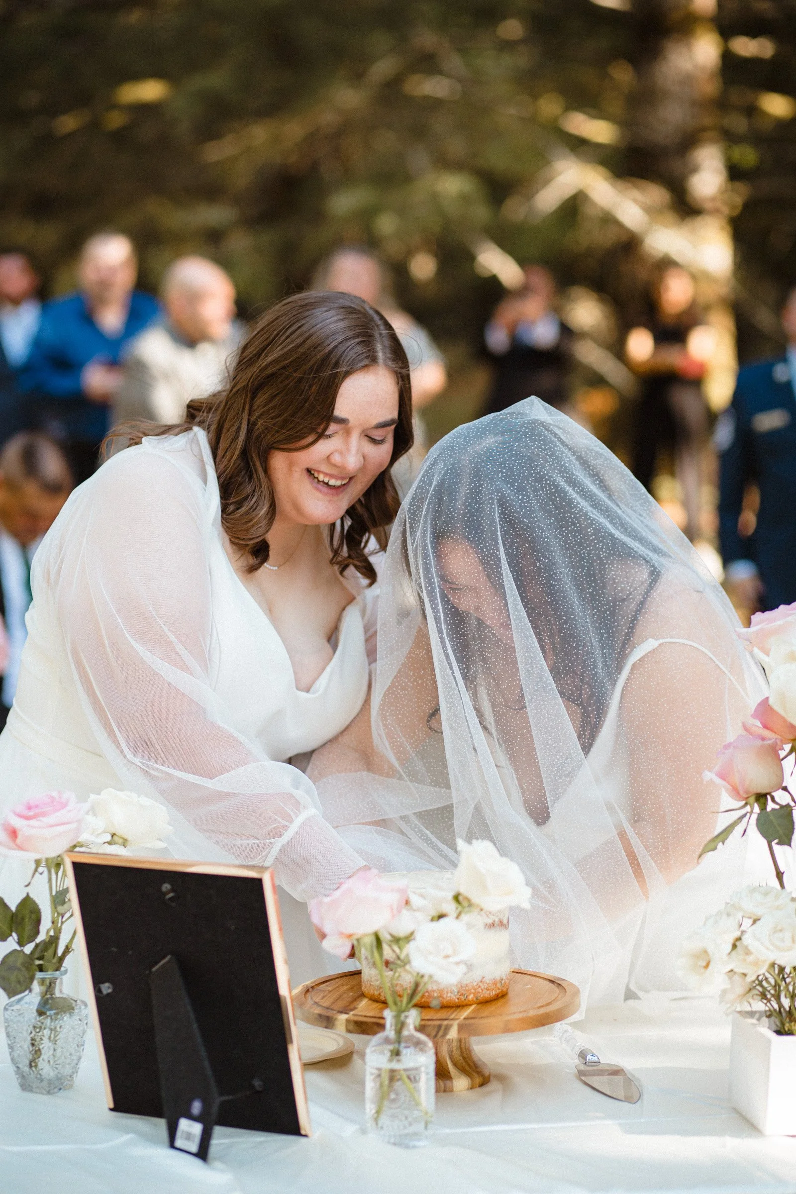 Two brides slicing their wedding cake at Lake Crescent in Port Angeles, Washington