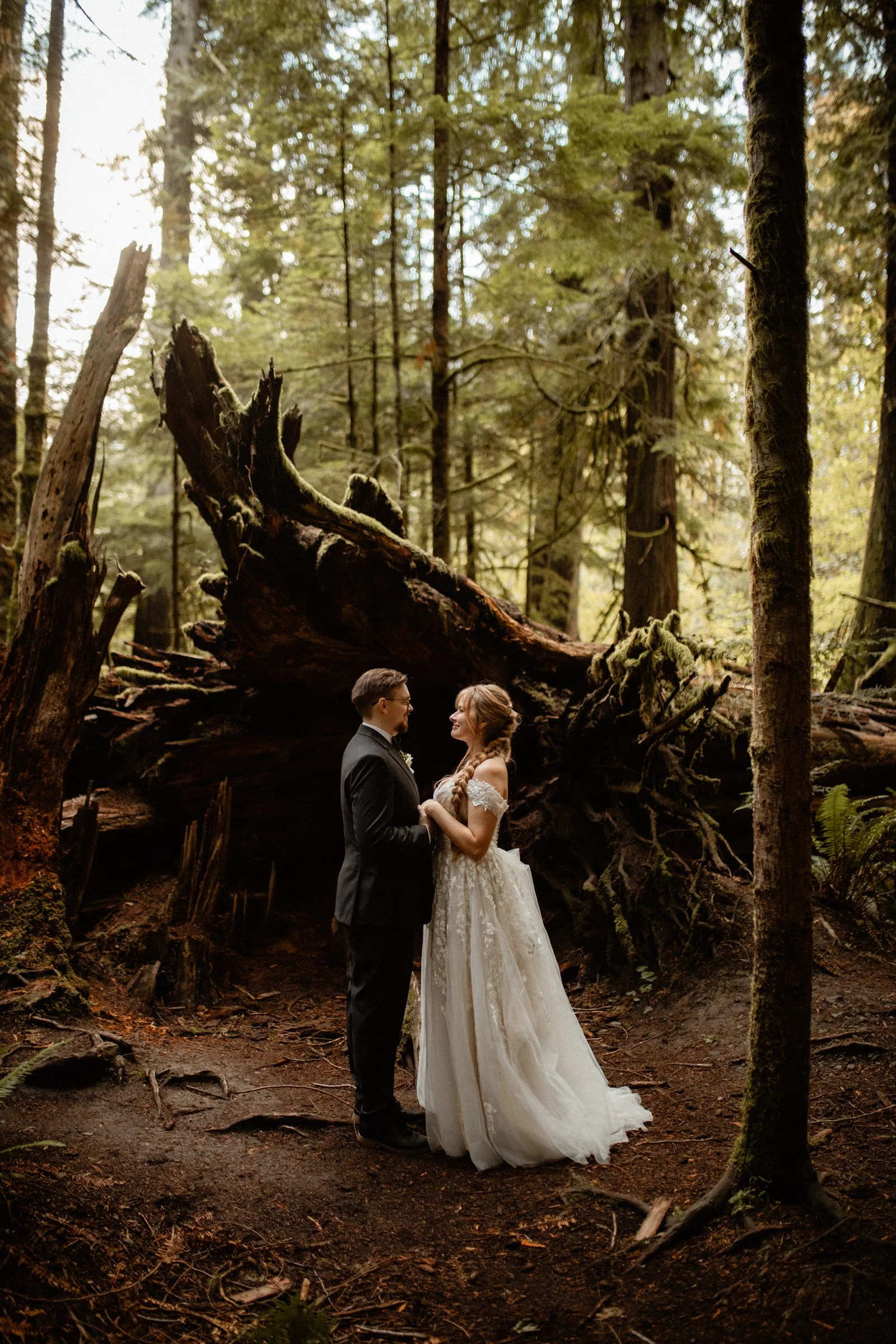 Bride and groom sharing a quiet moment surrounded by tall trees in a forest near Lake Crescent Lodge.