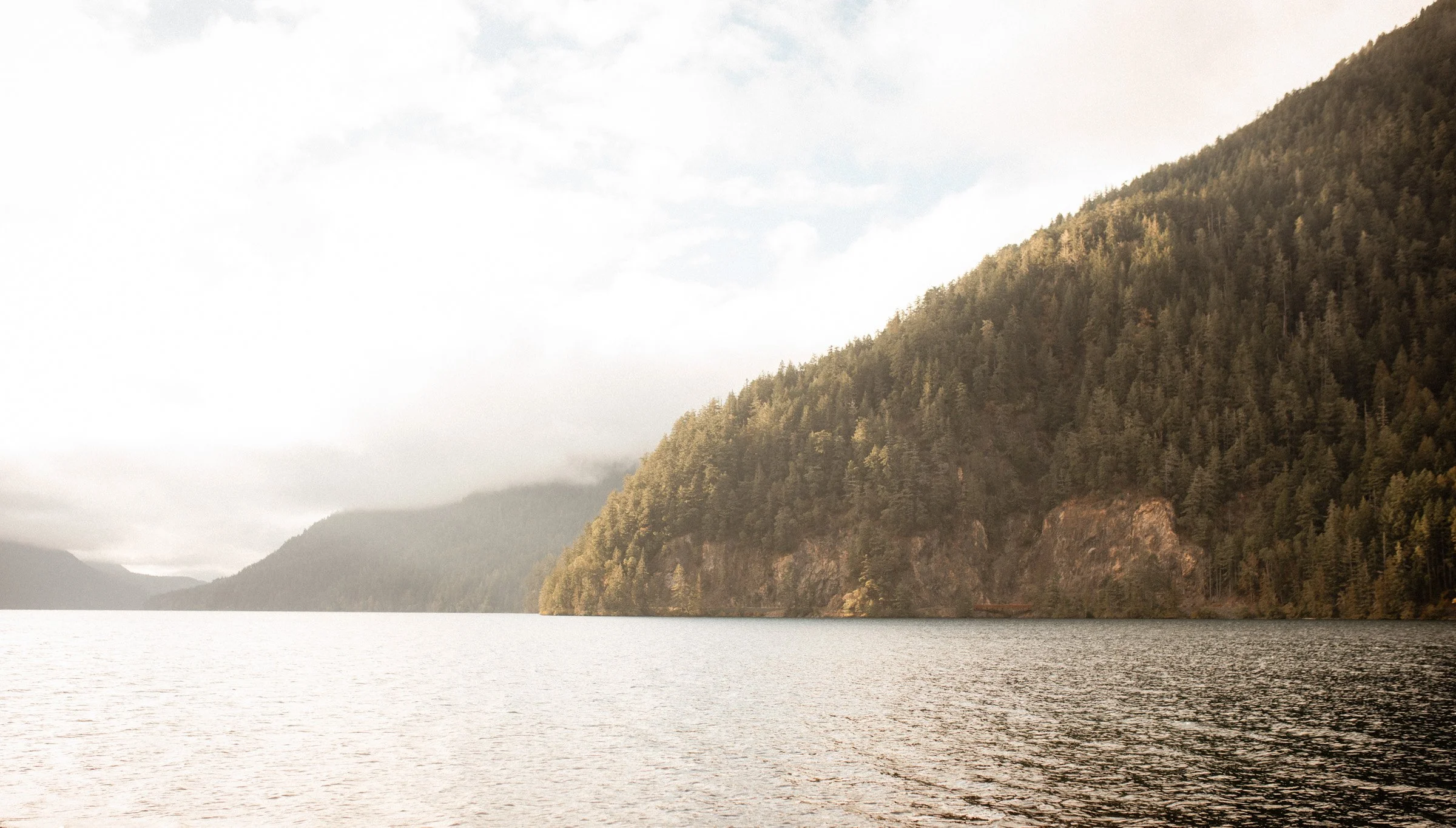 Landscape view of the blue waters and surrounding mountains of Lake Crescent near Lake Crescent Lodge in Port Angeles, WA.