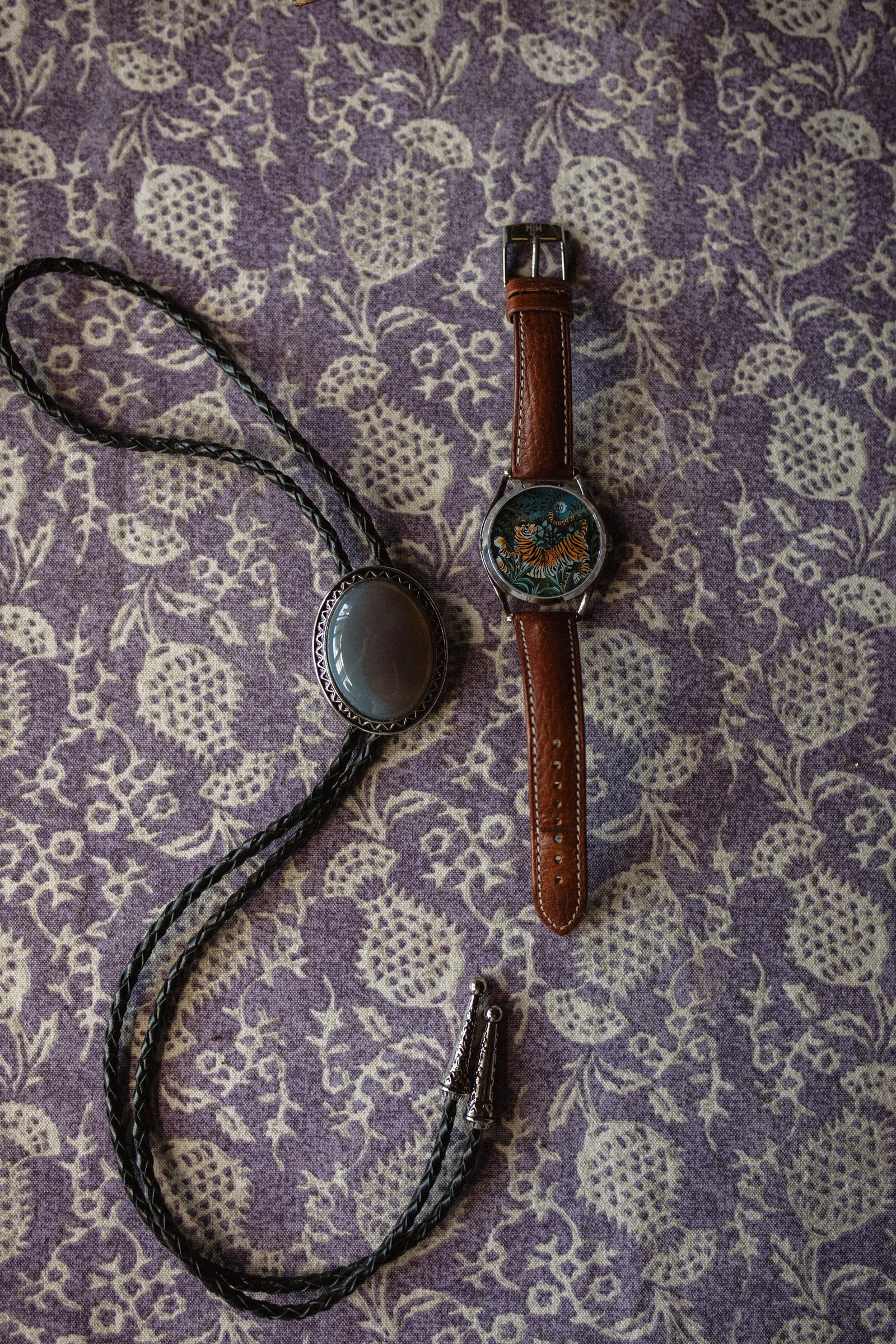 A grooms details, a bolo tie and a watch with a tiger face. Wedding at The Ruins in Queen Anne, Seattle