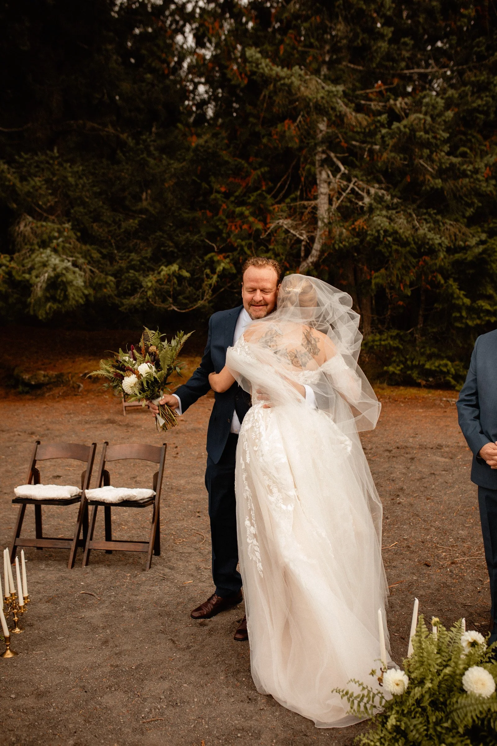 Emotional moment of the bride embracing her father as he walks her down the aisle at Lake Crescent Lodge in Port Angeles, Washington.