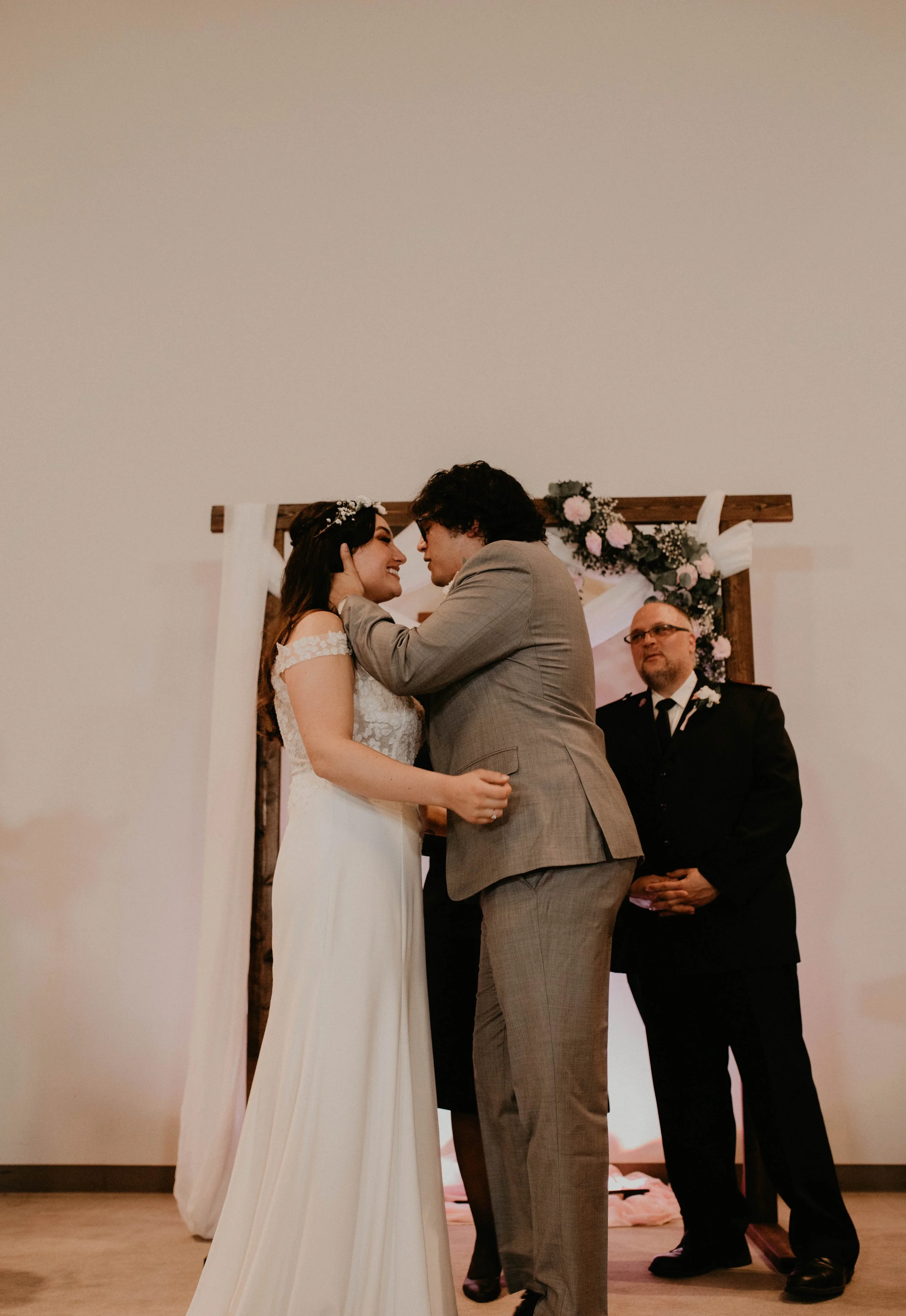 A couple getting married, standing closely and smiling at each other, with an officiant standing behind them during a wedding ceremony. Seattle, WA wedding photography.