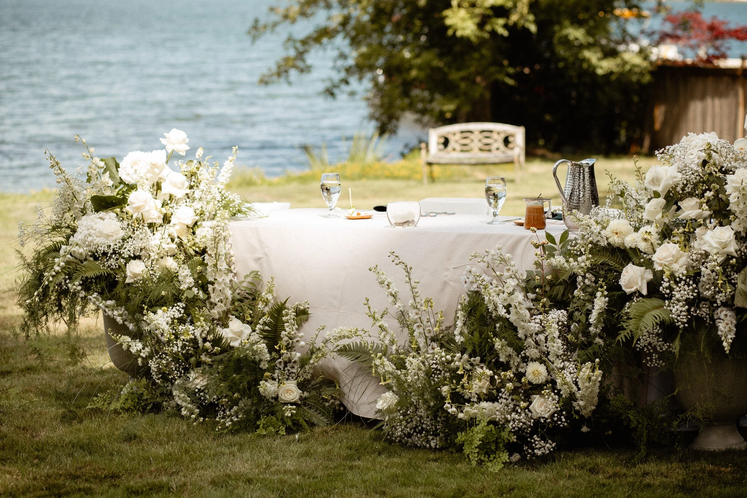 Beautiful sweetheart table ground floral arrangements at a lakeside wedding in Seattle, WA