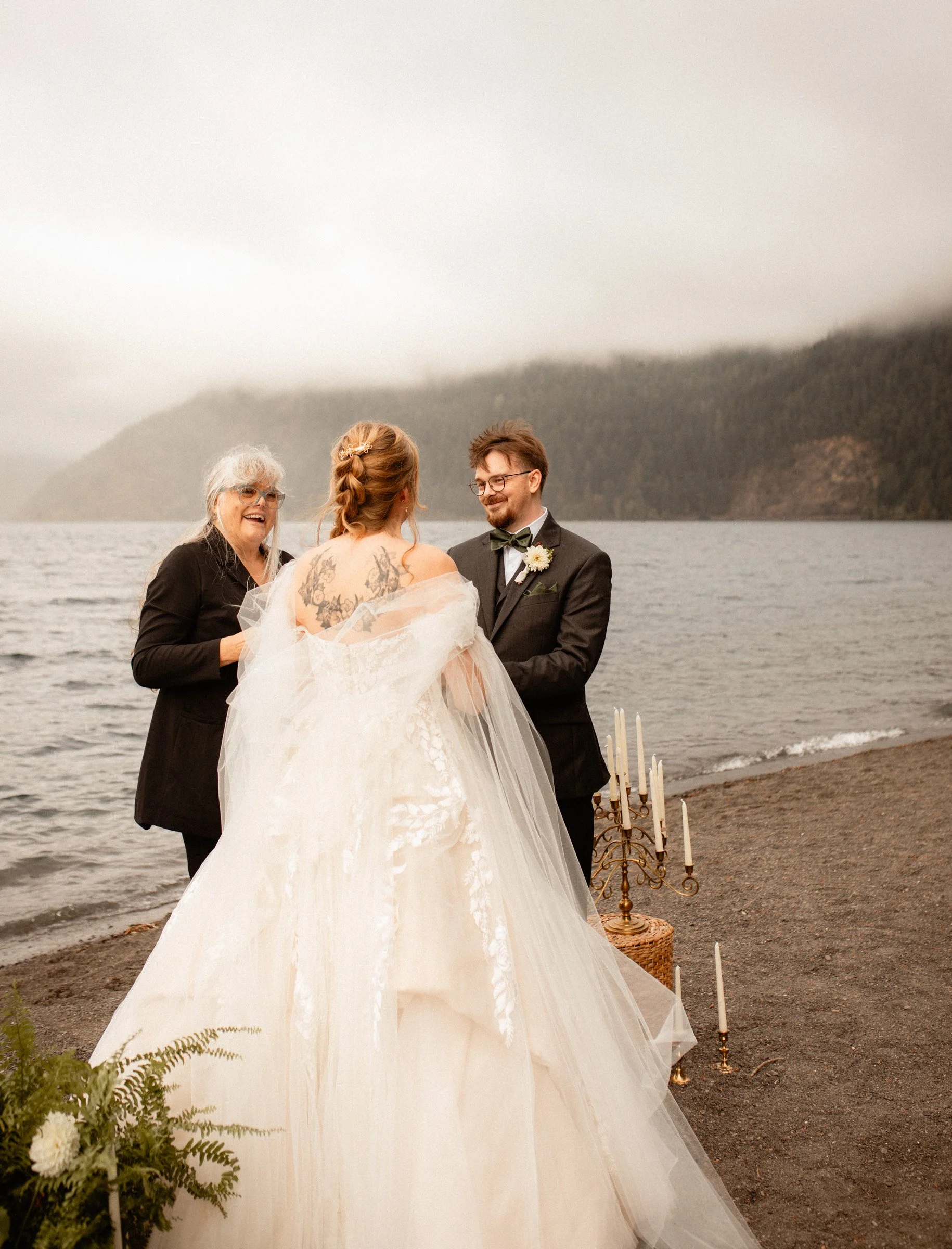 Groom holding the bride’s hands at the altar and smiling at her during their Lake Crescent Lodge wedding ceremony in Port Angeles, WA.
