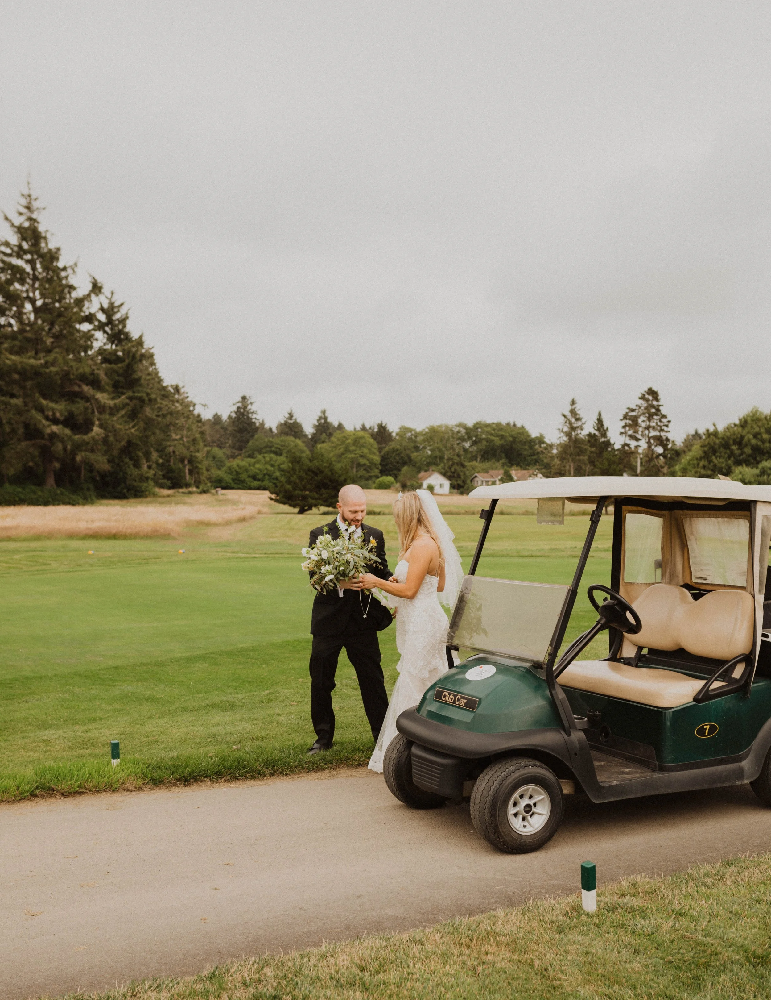 A bride and groom exchanging vows on a golf course, with a golf cart nearby, under overcast skies. Long Beach, WA wedding photography.
