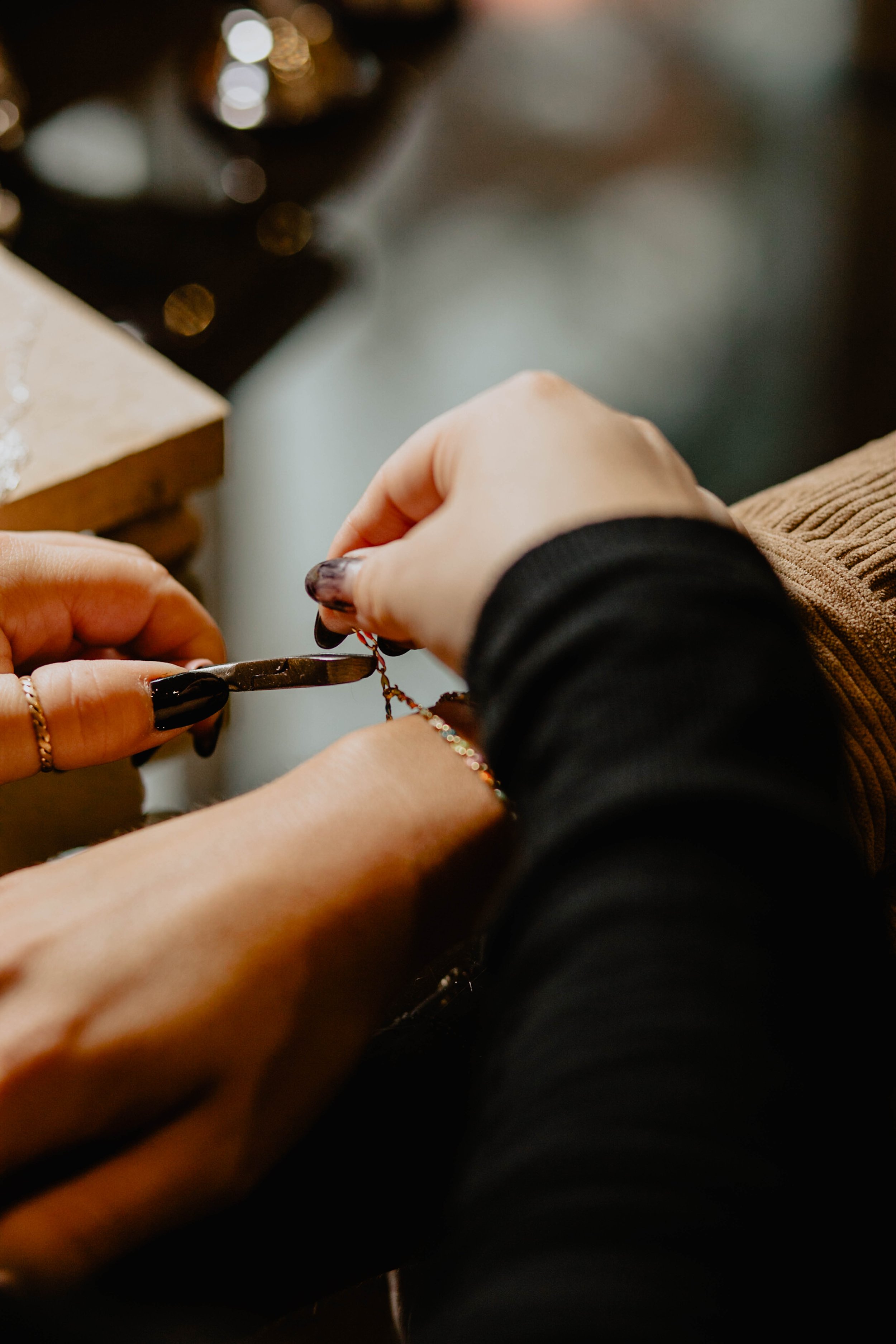 Person working on jewelry with pliers, jewelry pieces and tools on a workbench. Seattle professional head shot photography