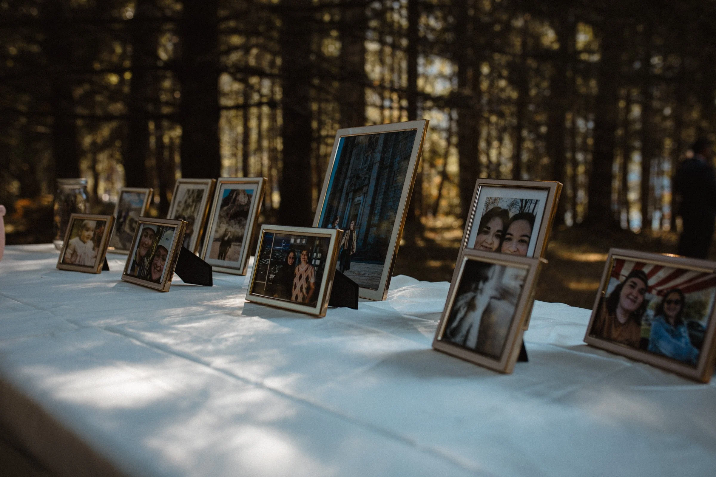 The couples welcome table placed in the forest opening, atop it framed photos of loved ones and memories. Wedding in Port Angeles, WA.