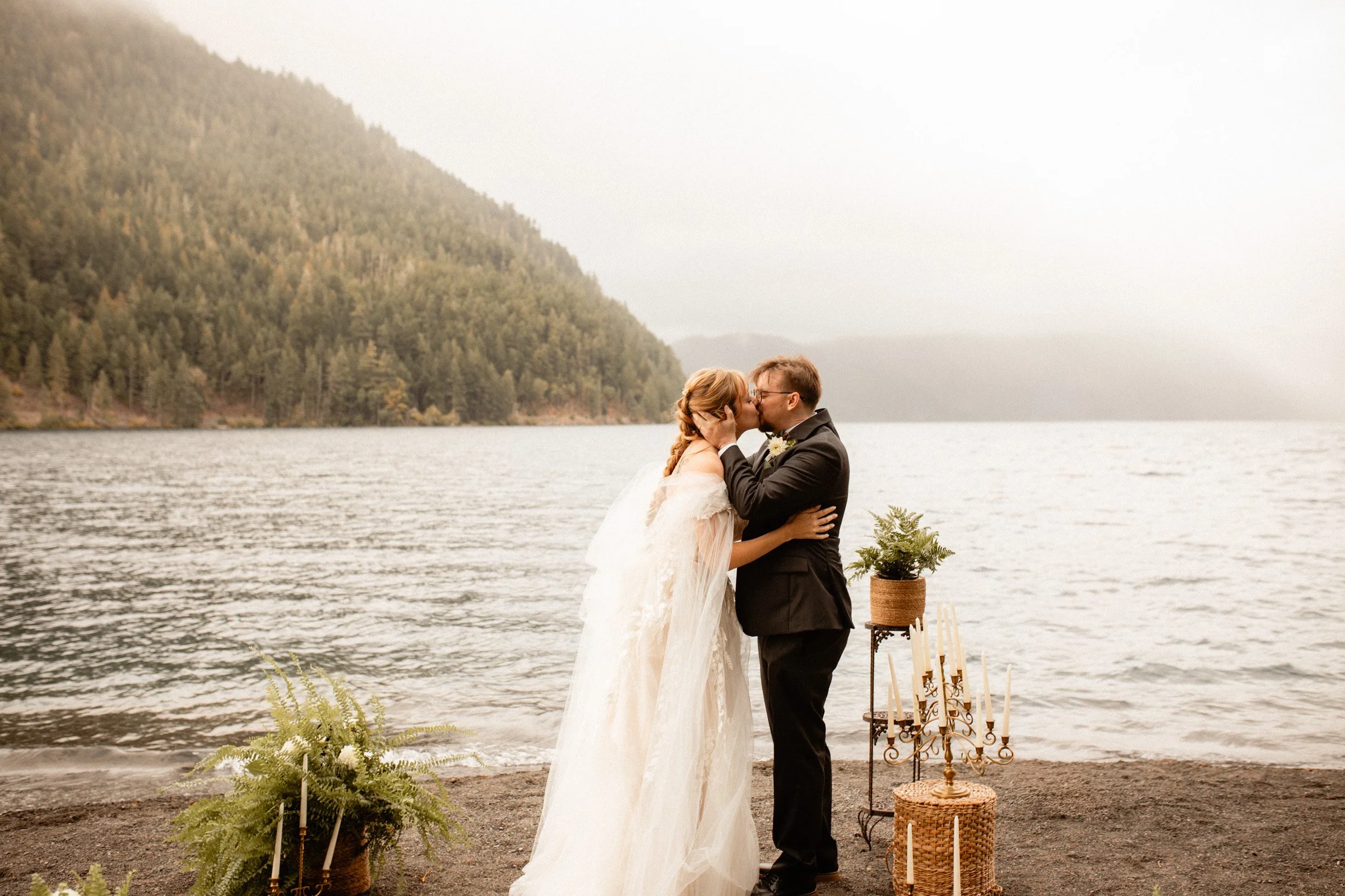 Bride and groom sharing their first kiss at the altar during their Lake Crescent Lodge wedding ceremony in Port Angeles, WA.