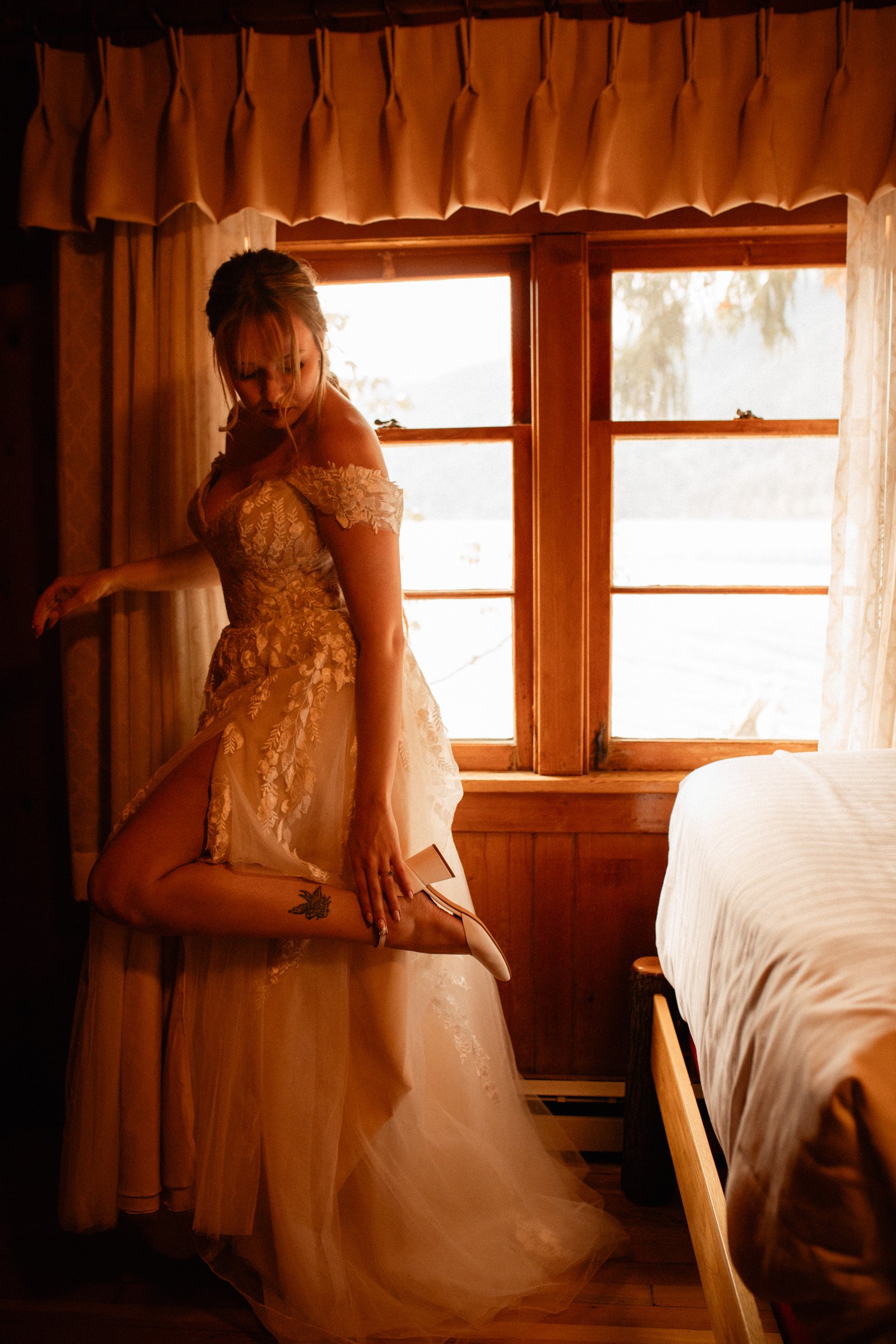 Bride putting on her wedding shoes in the bridal suite at Lake Crescent Lodge in Port Angeles, WA.