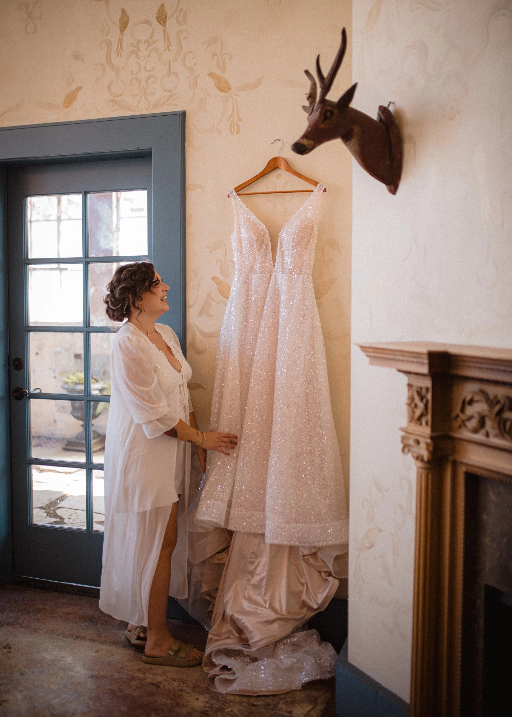 Bride admiring her wedding dress before putting it on, at The Ruins wedding venue in Queen Anne, Seattle