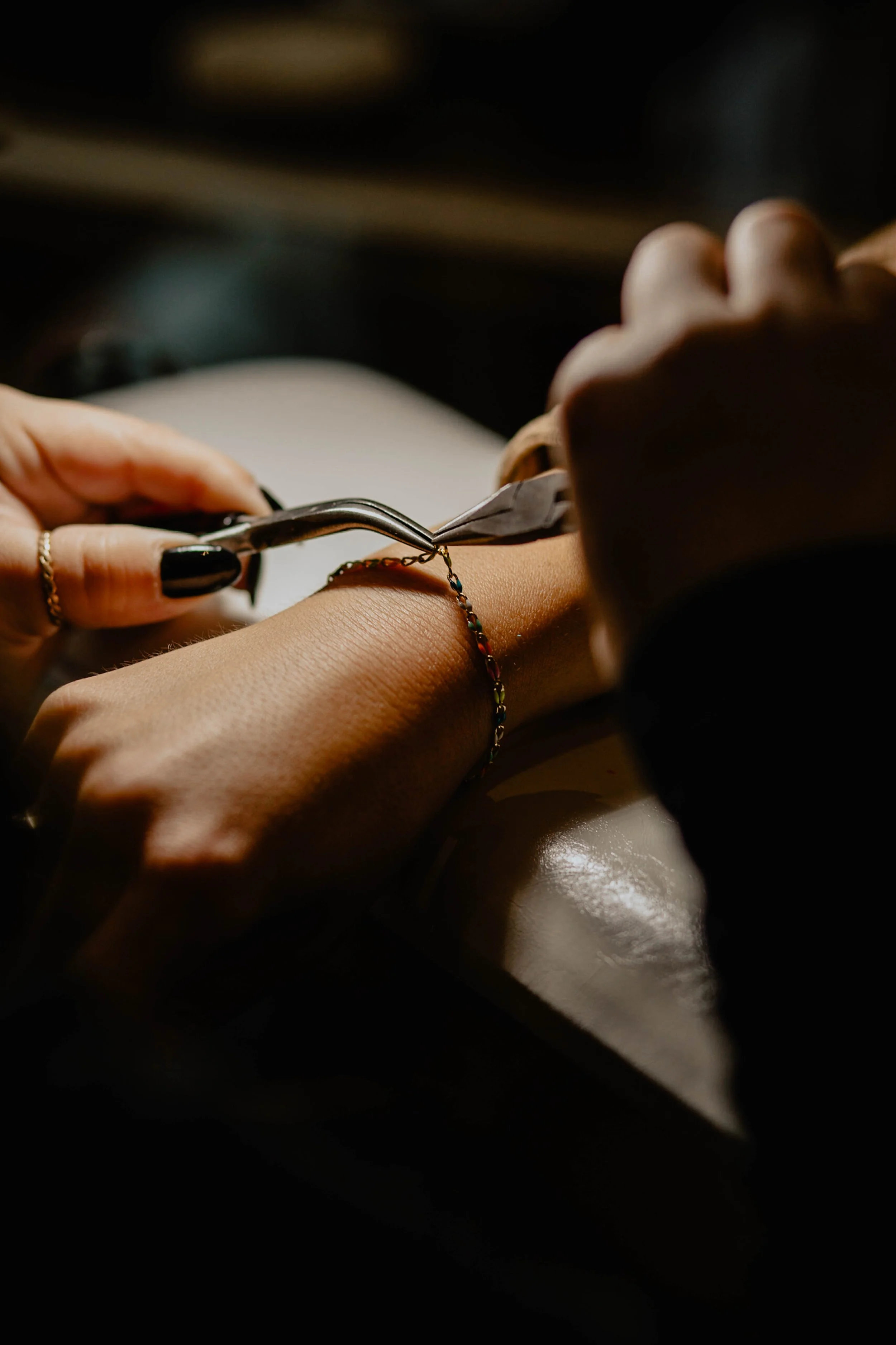 A person is getting a tattoo on their wrist, with a tattoo artist using a tattoo needle and ink. Seattle professional head shot photography