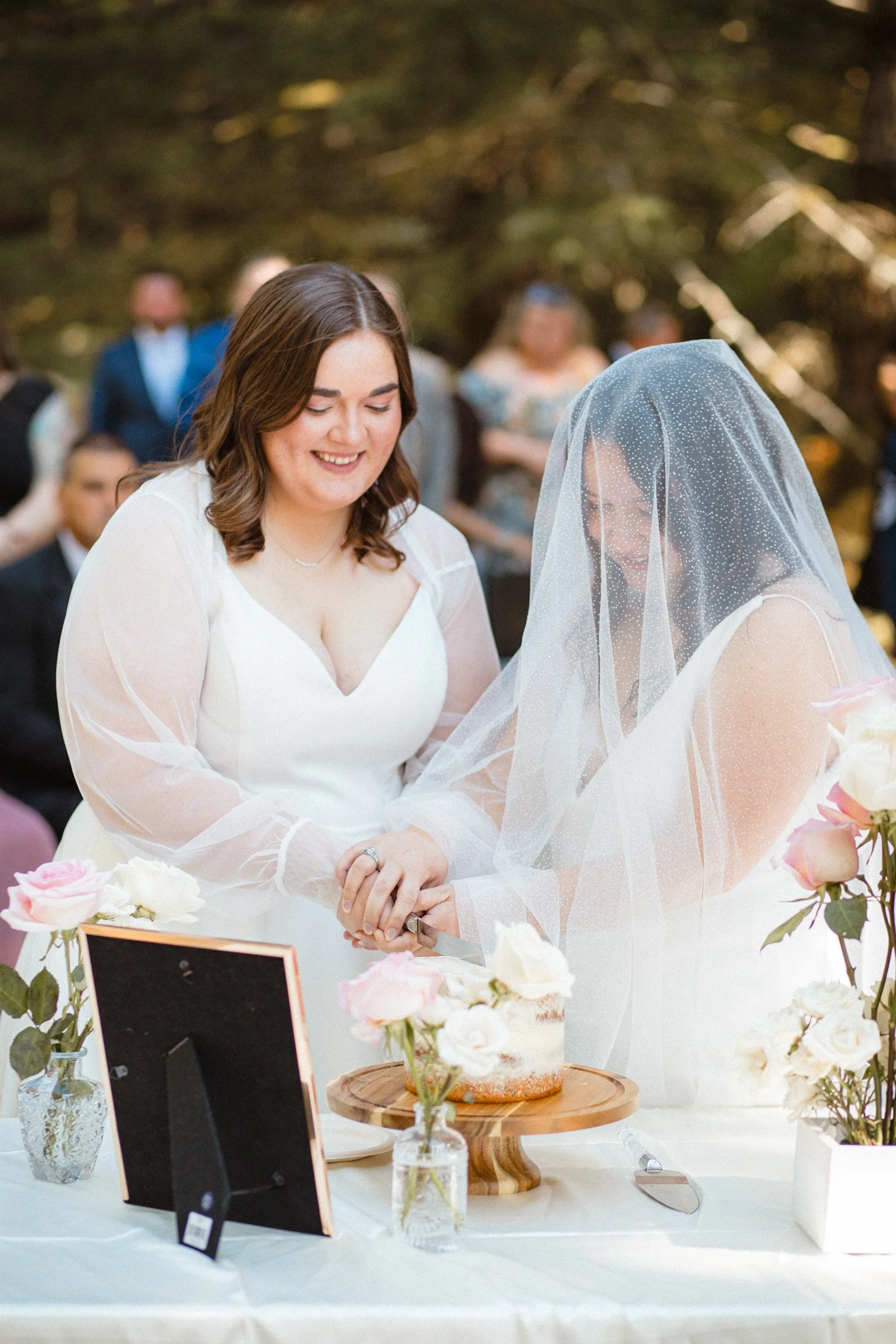 Two brides slicing their wedding cake at Lake Crescent in Port Angeles, Washington