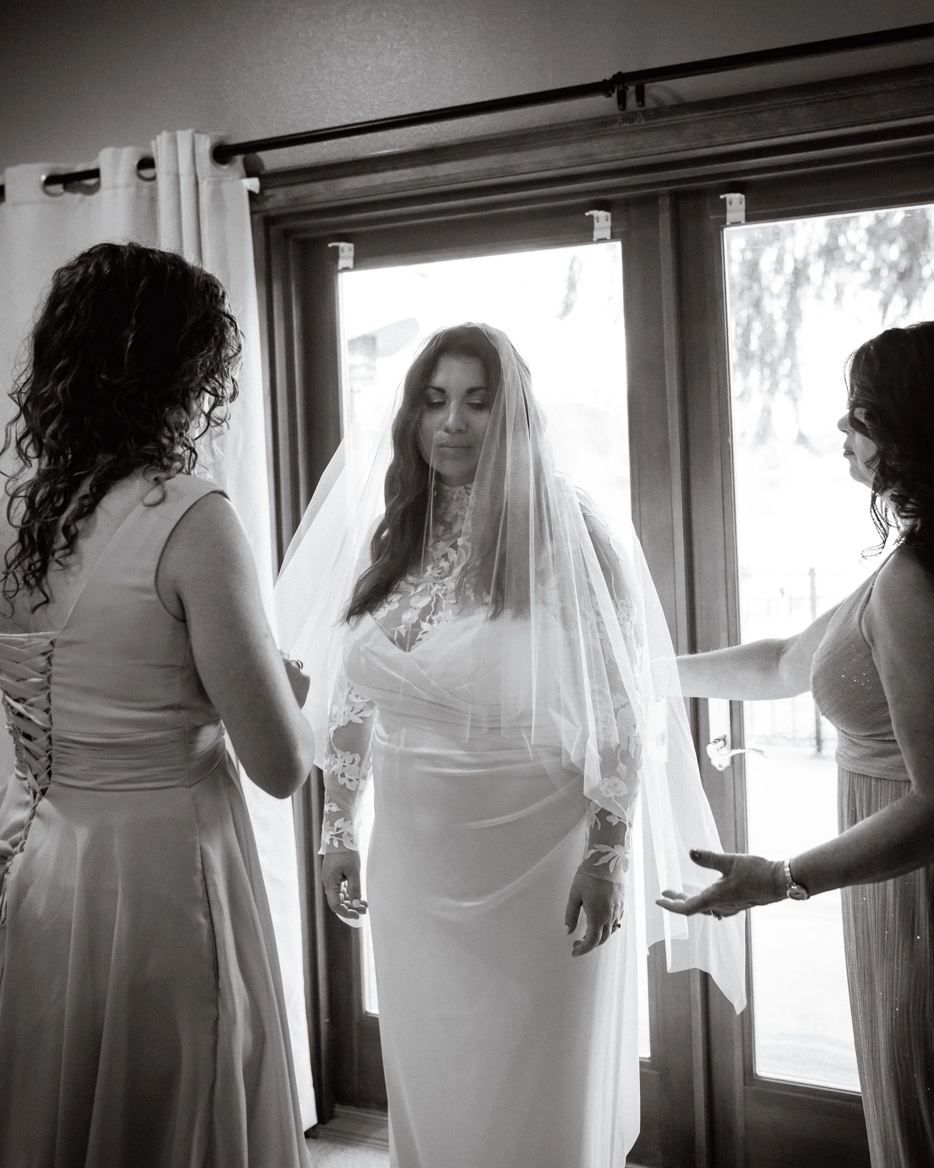 Maid of honor and mother of the bride helping the bride with her veil before her lakeside wedding in Seattle, WA