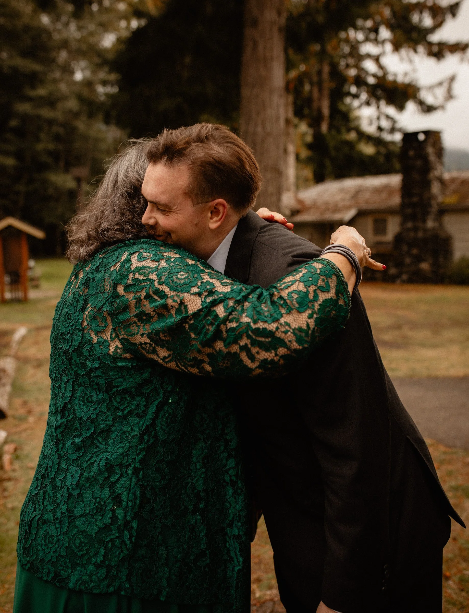 Emotional moment of the groom embracing his mother before the Lake Crescent wedding ceremony at Lake Crescent Lodge.