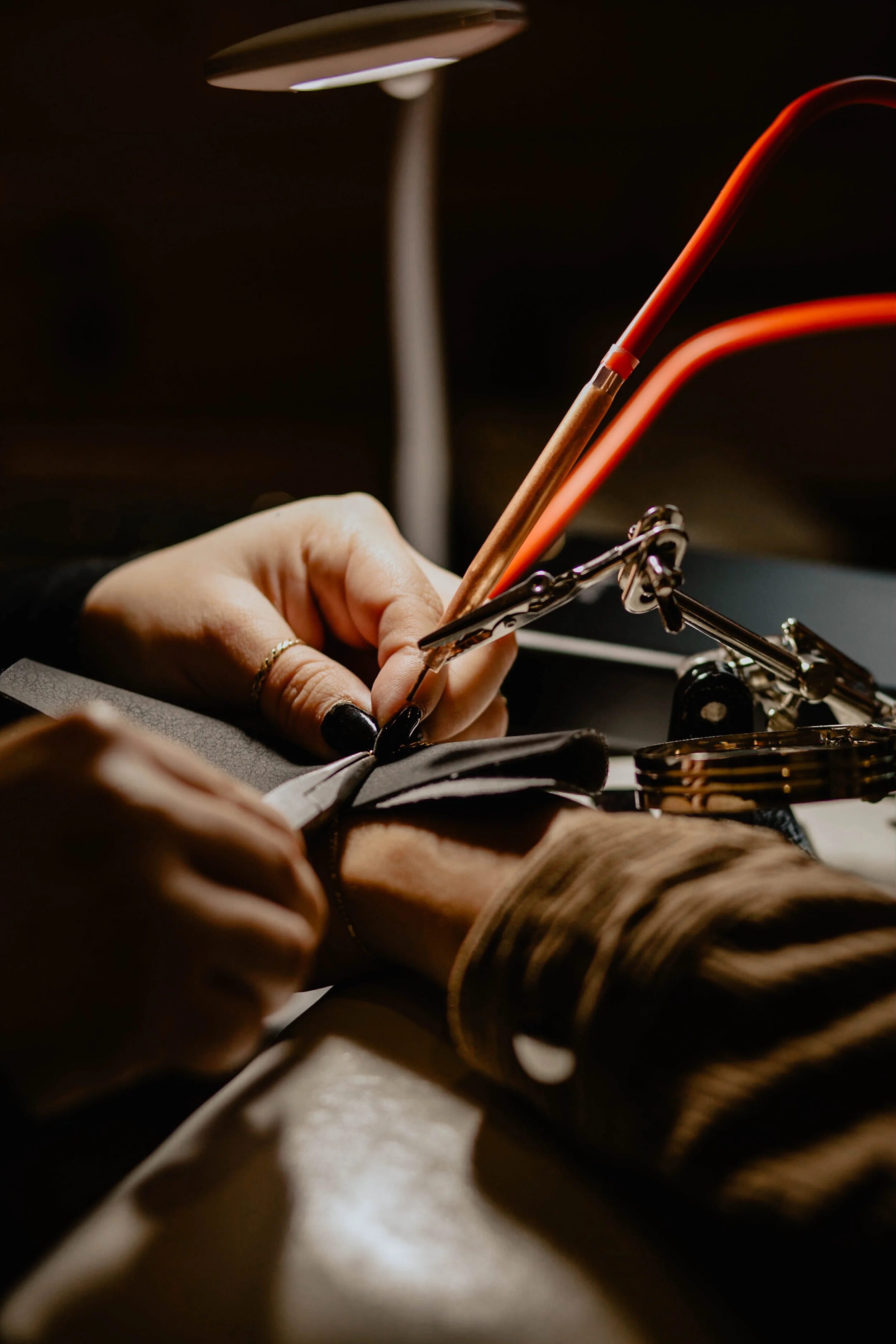 A person working with leather, stitching with a sewing machine in a dimly lit workspace. Seattle professional head shot photography