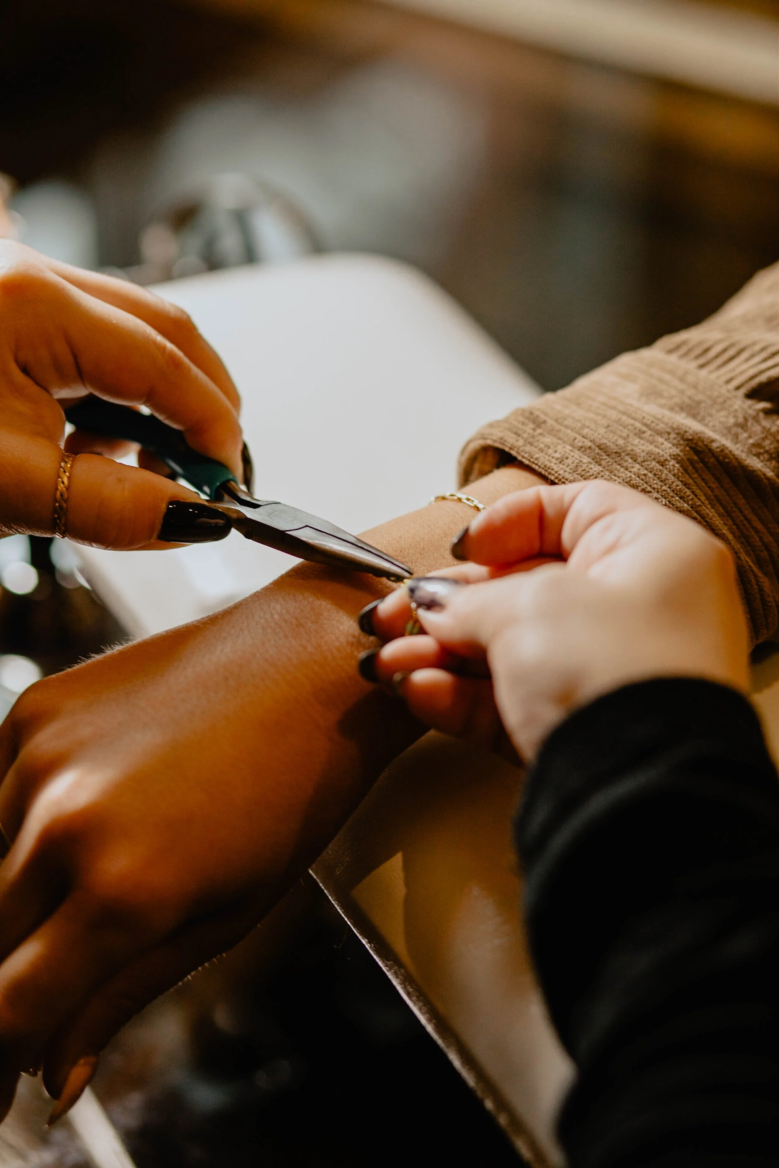 Person with dark nail polish getting a tattoo on their arm from a tattoo artist. Seattle professional head shot photography