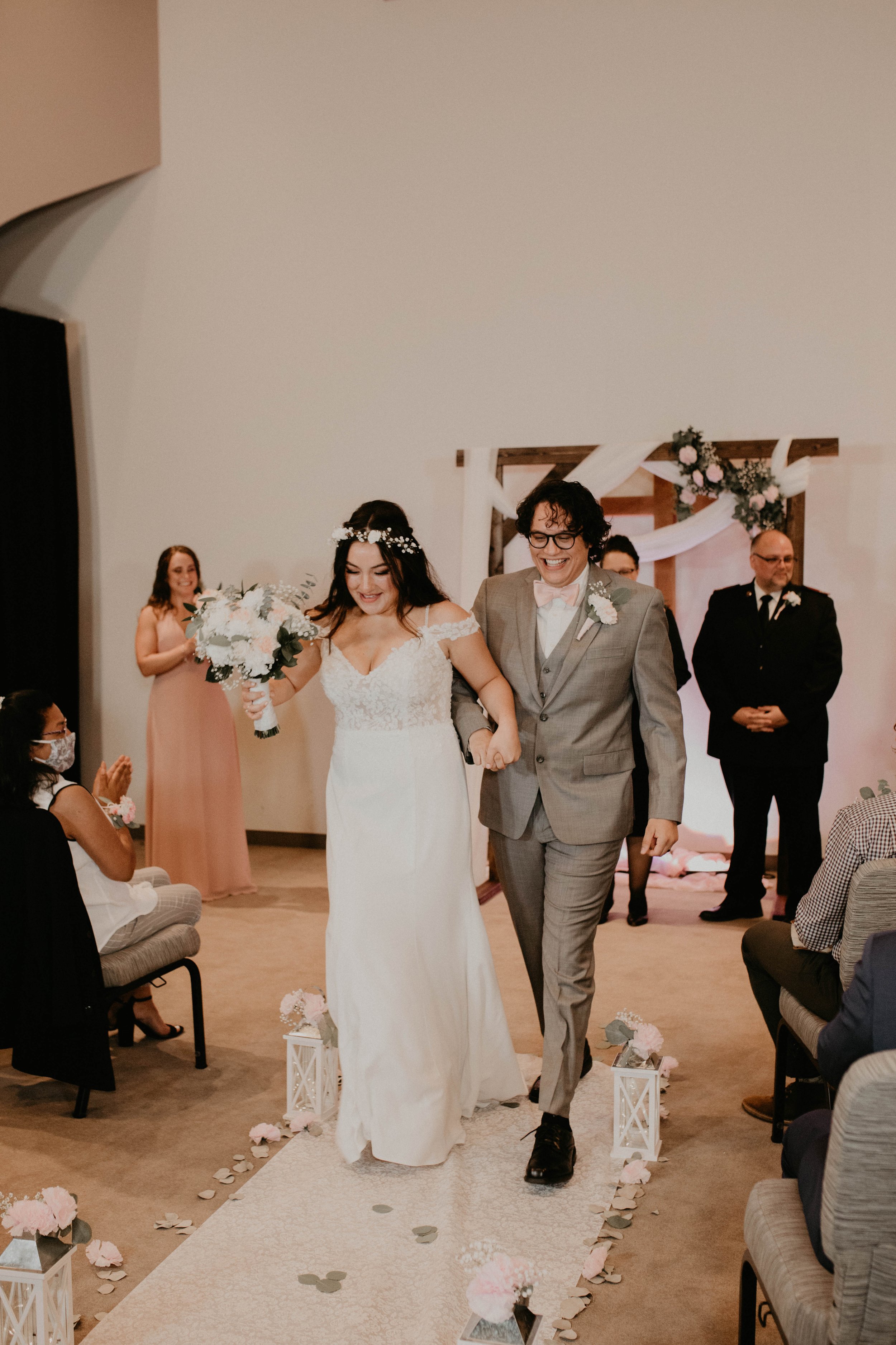 A newlywed couple walking down the aisle during their wedding ceremony, surrounded by guests and wedding decor. Seattle, WA wedding photography.