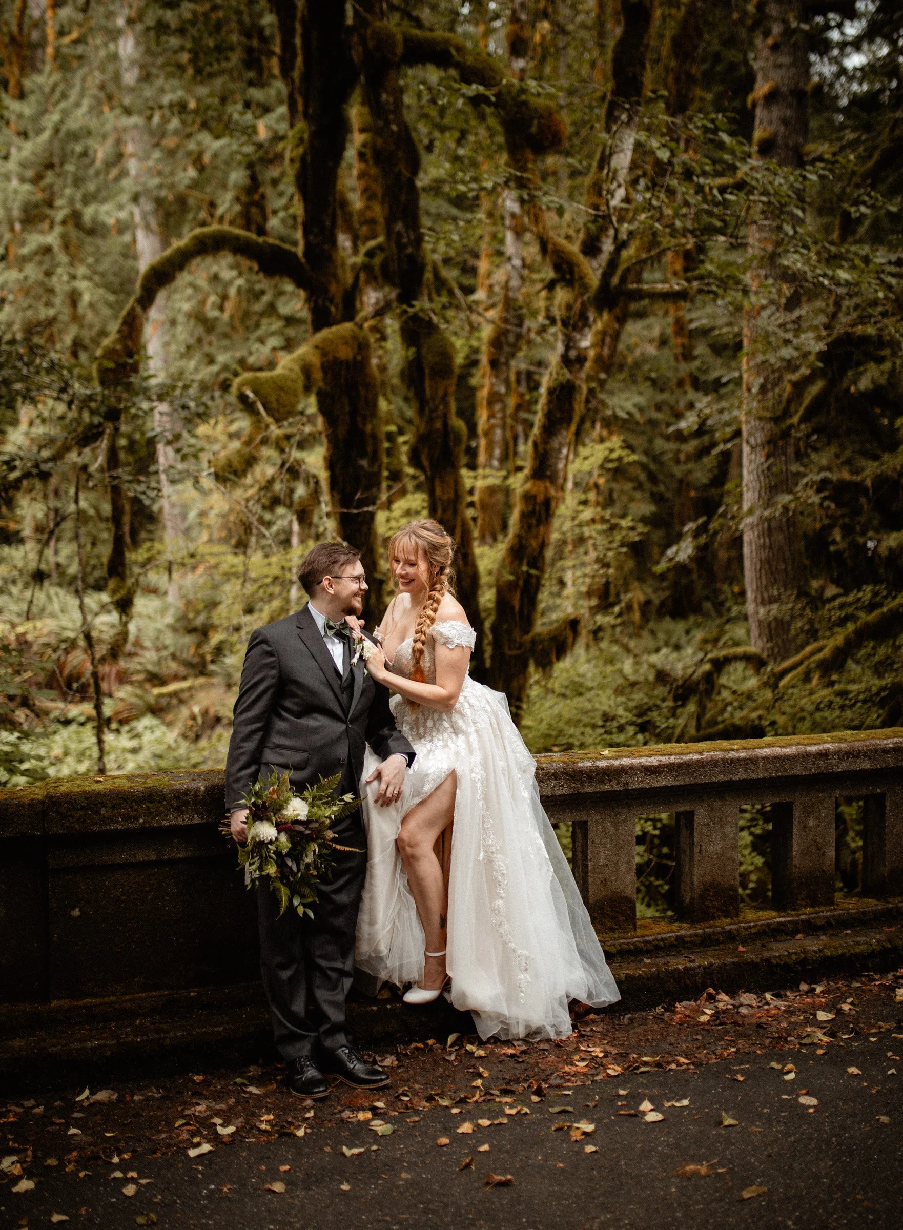 Bride and groom walking hand-in-hand through the forest during their Lake Crescent wedding at Lake Crescent Lodge.