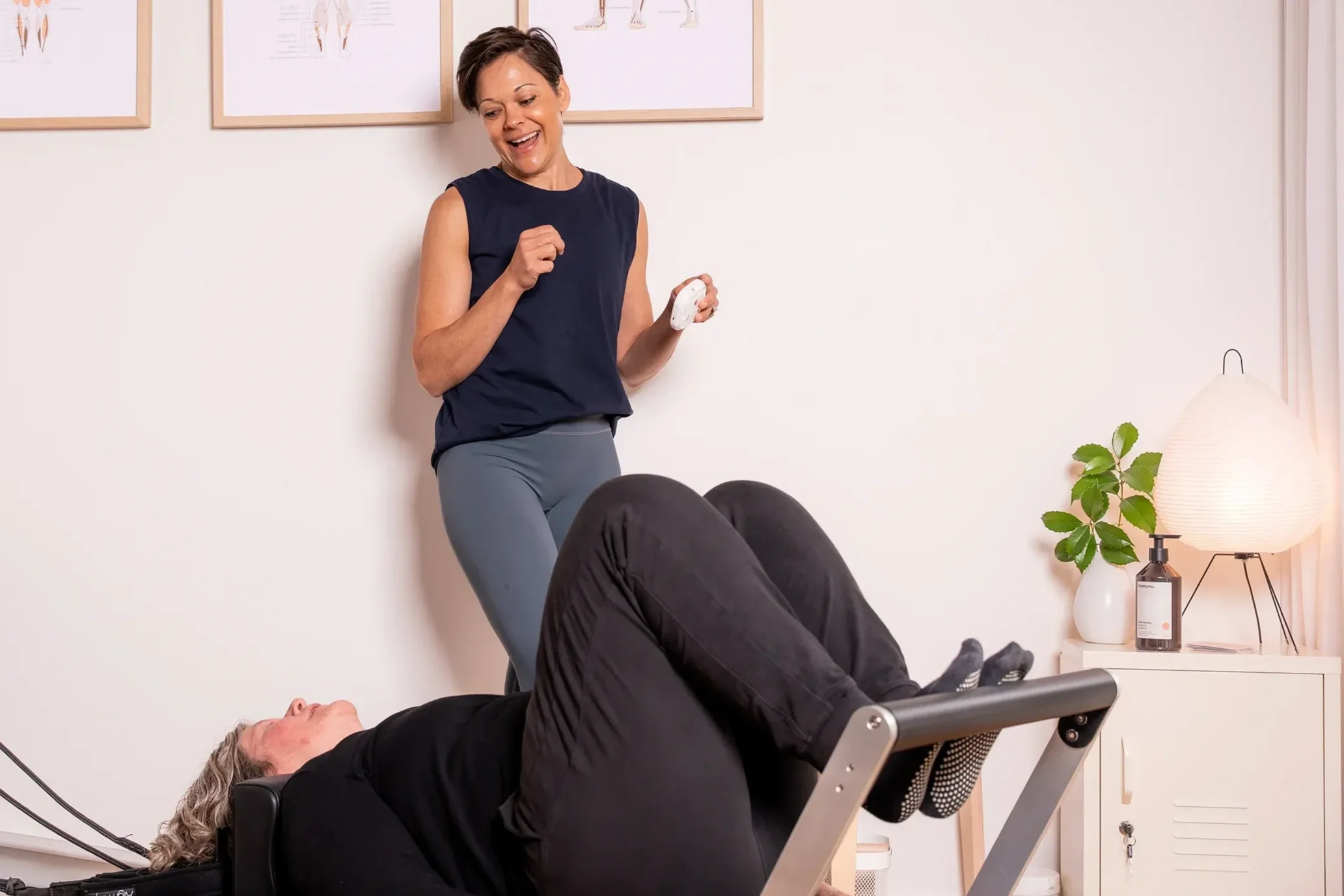 Clinical Pilates practitioner Tegan Duncan guiding a client through a supported reformer exercise during a personalised session.