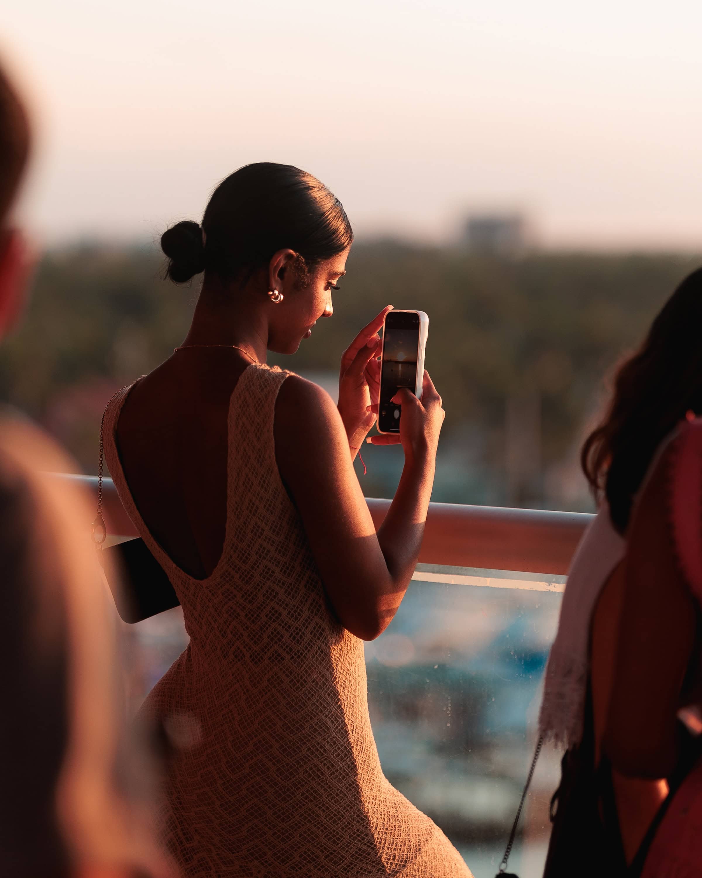 Guest capturing sunset views at Sunset Club rooftop restaurant & bar in Hollywood Beach